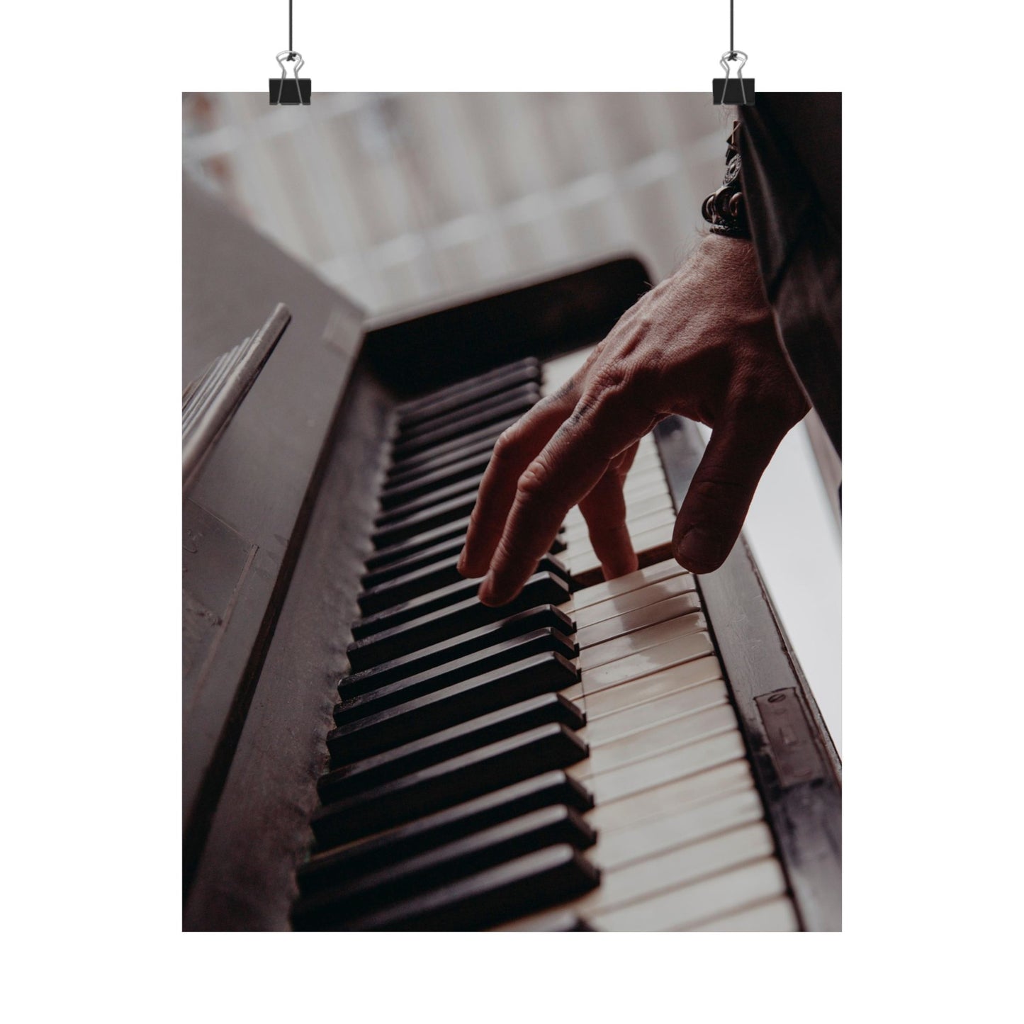 Hand playing a piano with a blurred background