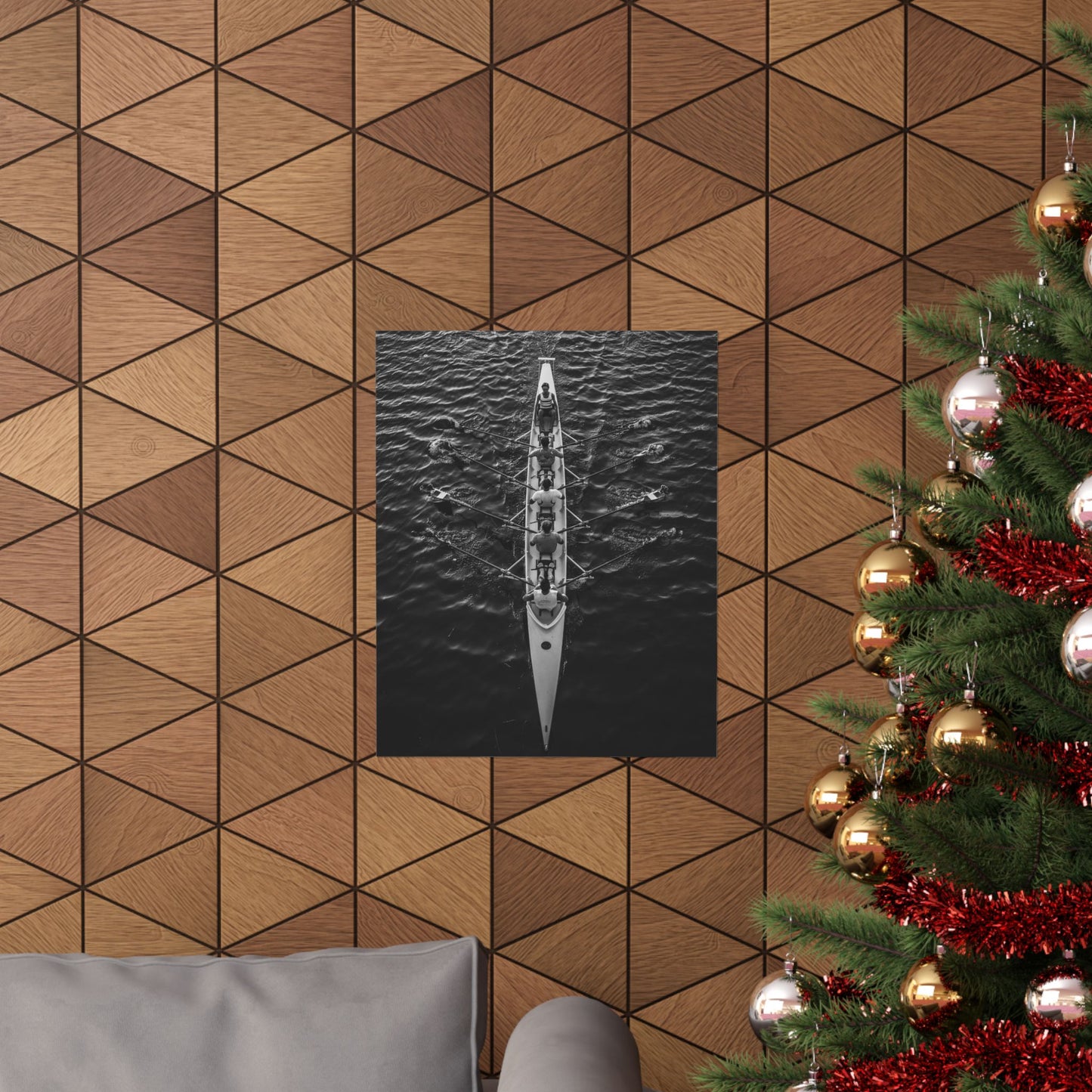 Wooden wall with geometric pattern, framed picture of a boat, and Christmas tree with decorations.