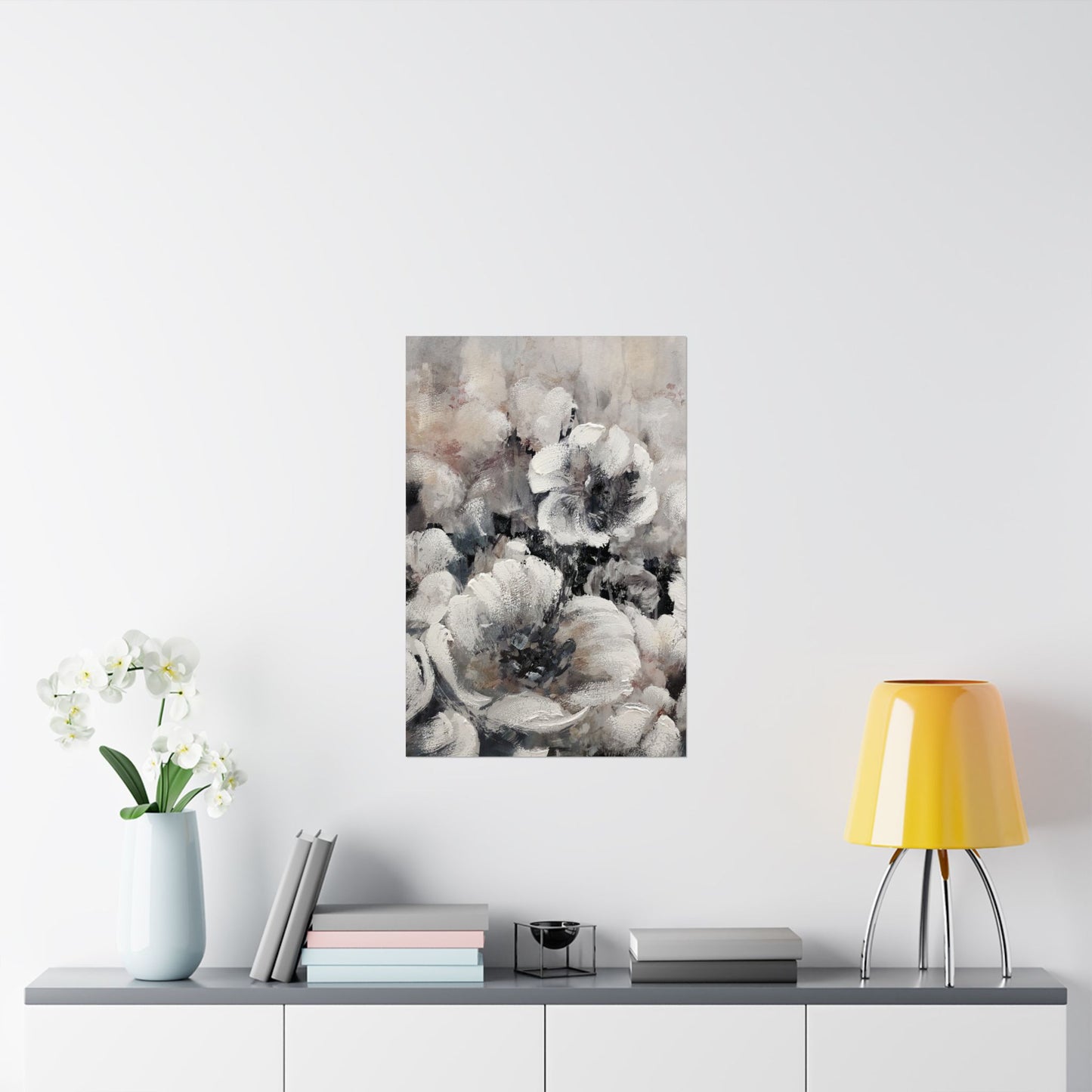 Framed floral art piece on a wall above a table with decor items.