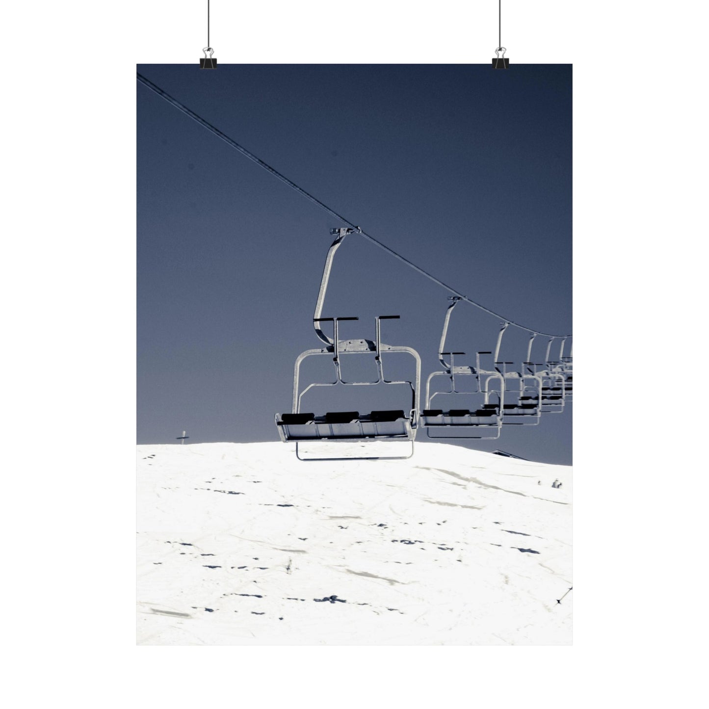 Ski lift on a snowy mountain with clear blue sky