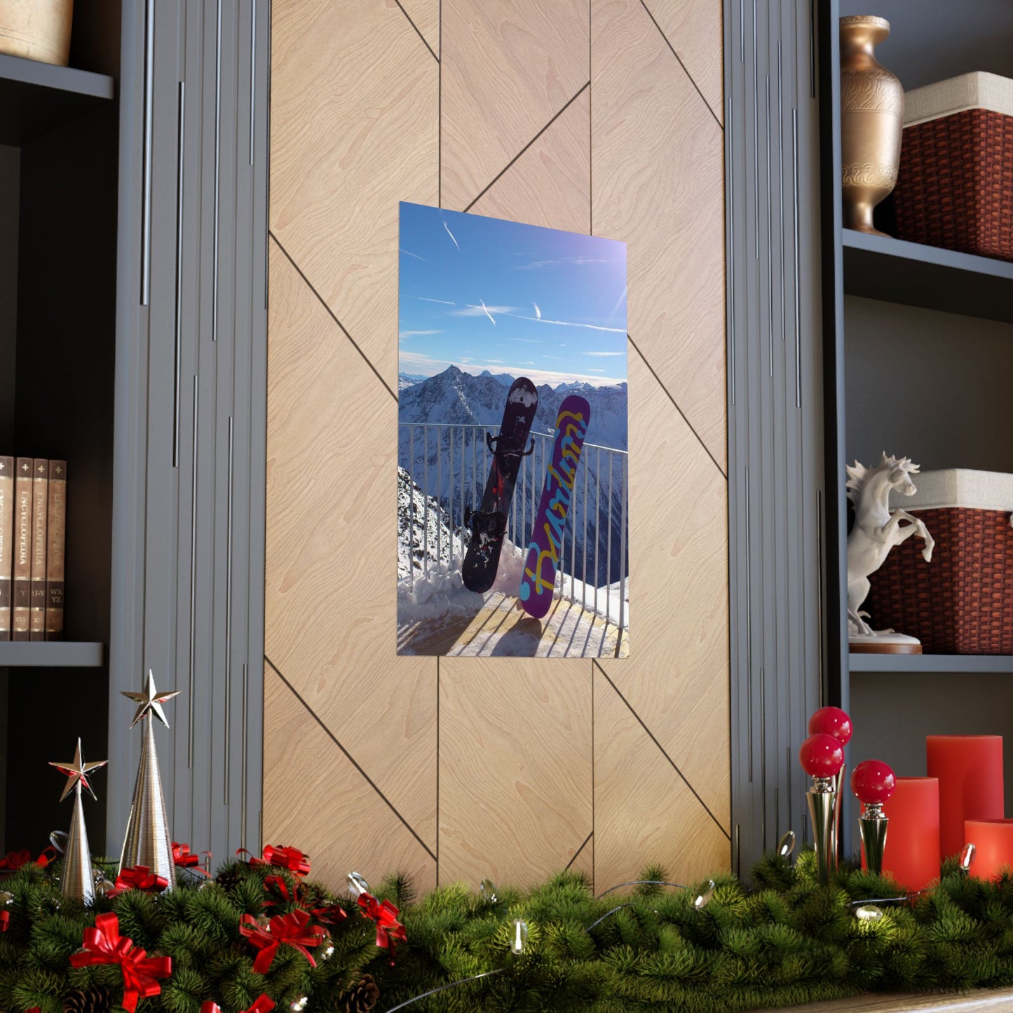 Decorative wall mirror with a mountain view on a wooden wall, surrounded by festive decorations.