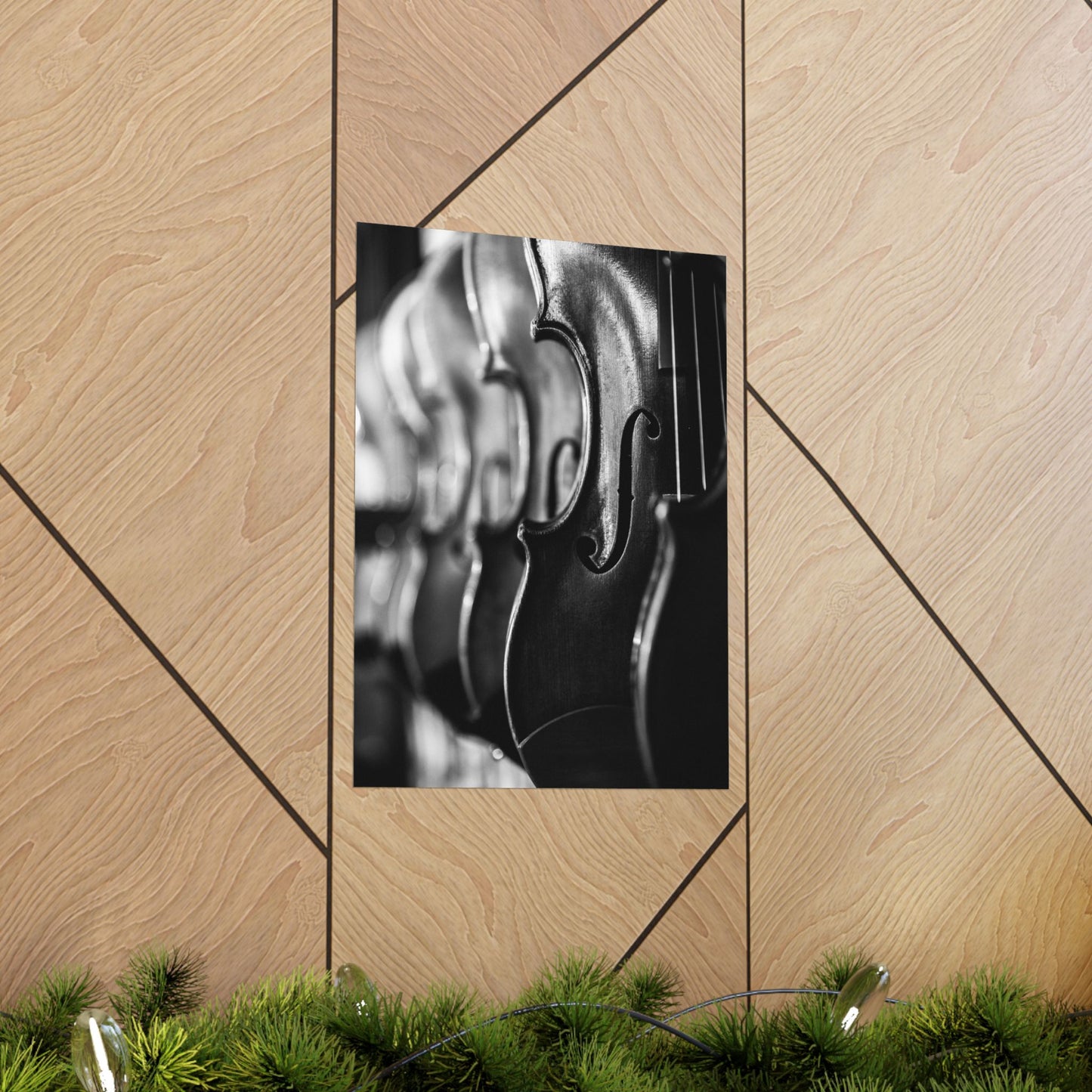 Framed black and white artwork of a violin on a wooden wall.