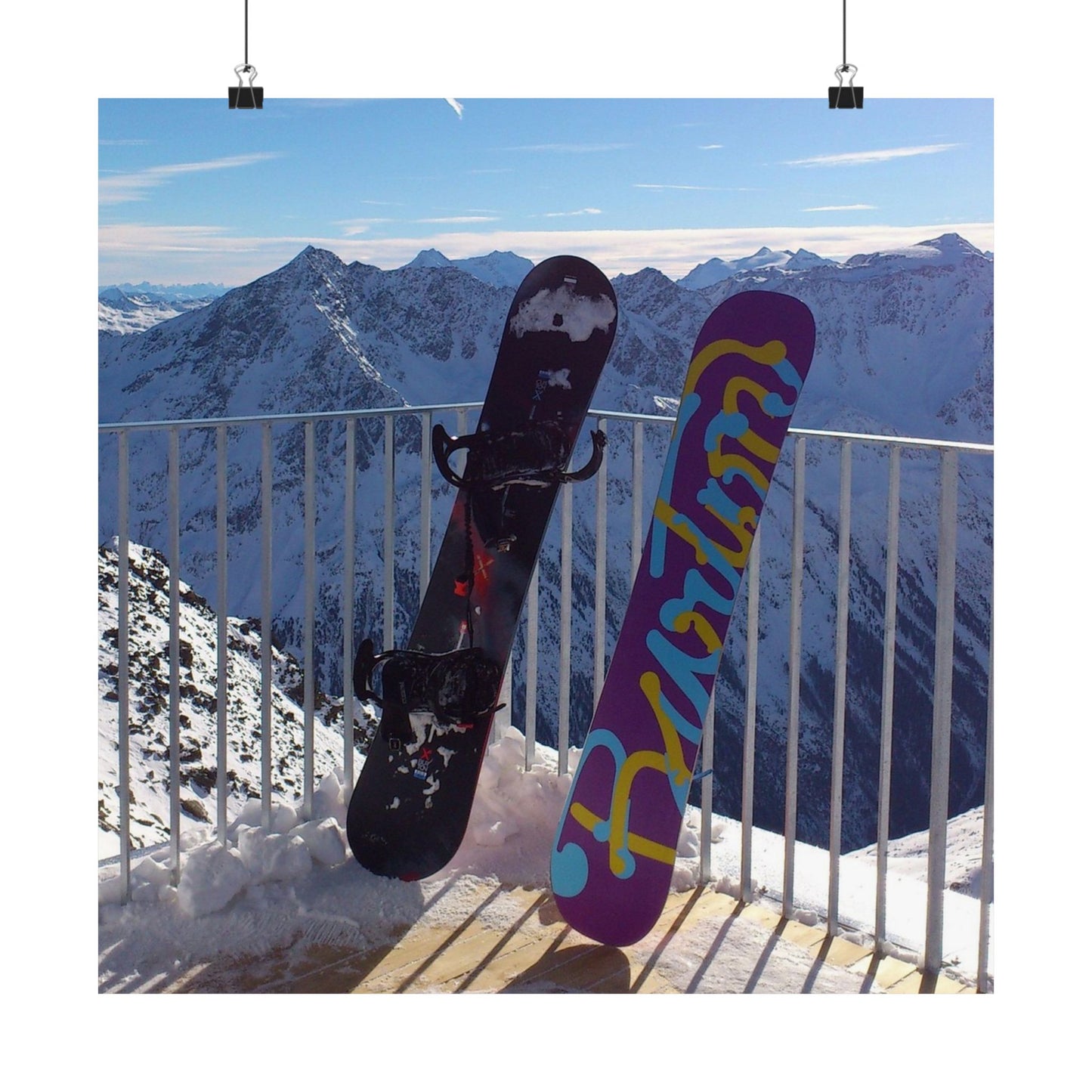 Two snowboards against a mountainous background