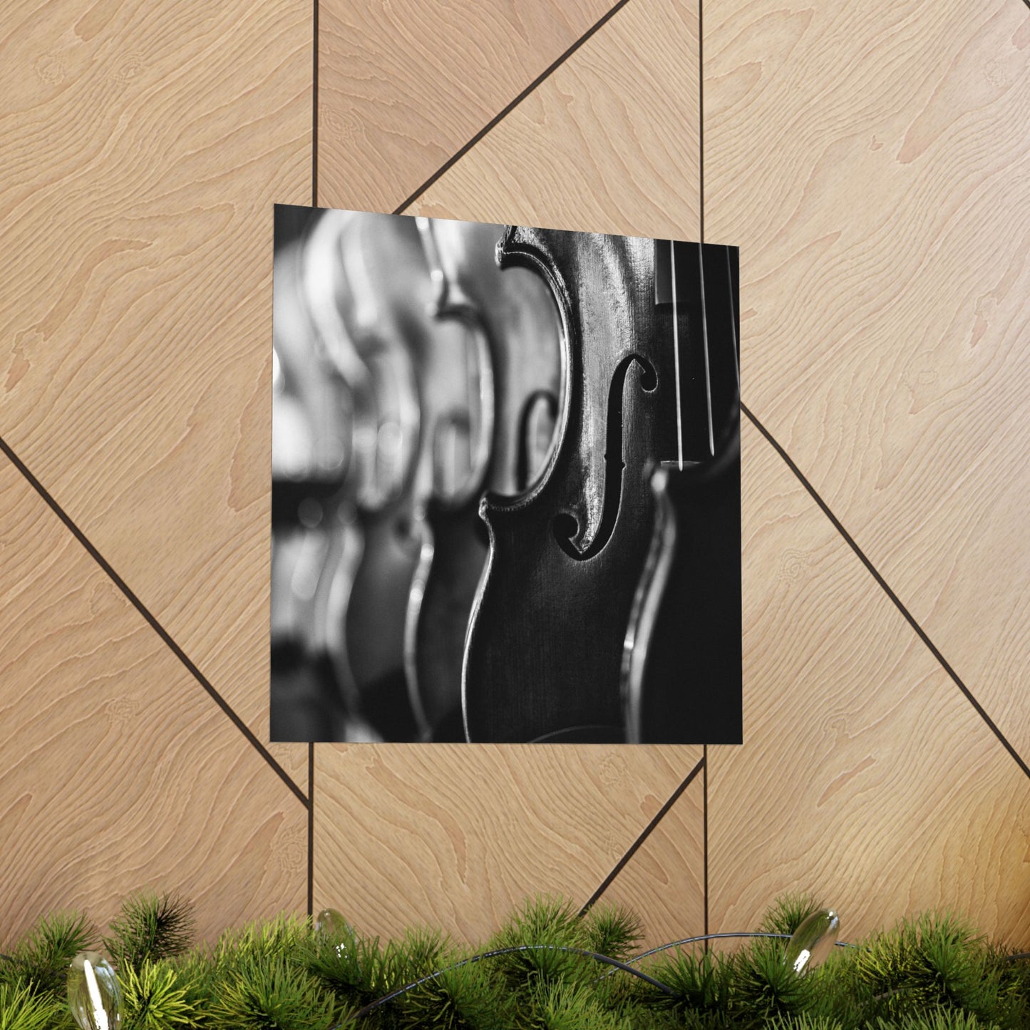 Close-up of a violin's f-hole on a wooden wall with greenery at the bottom.