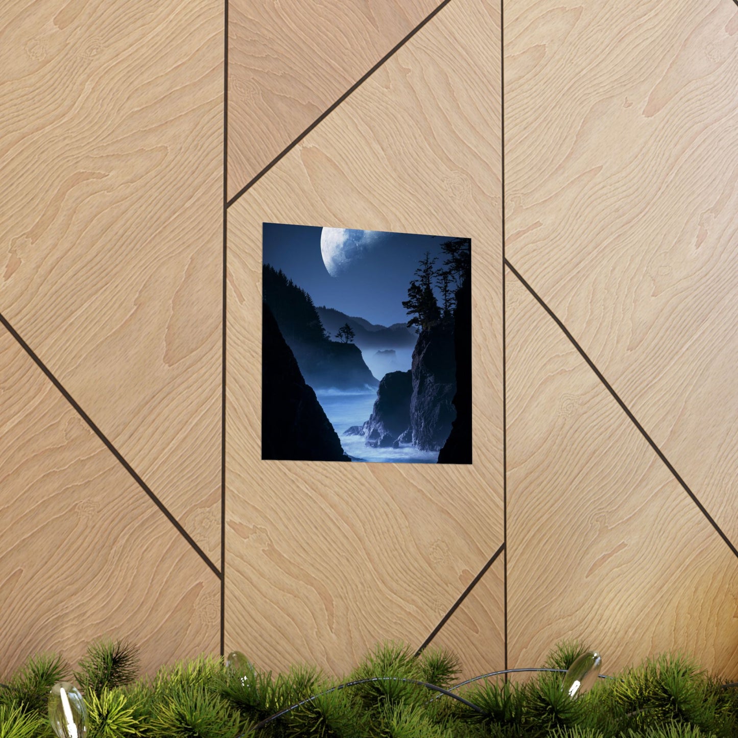 Framed nature print of a moonlit mountain scene on a wooden wall.