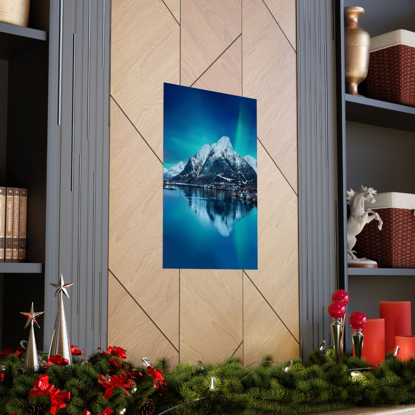 Framed mountain landscape print on a wall with Christmas decorations below.