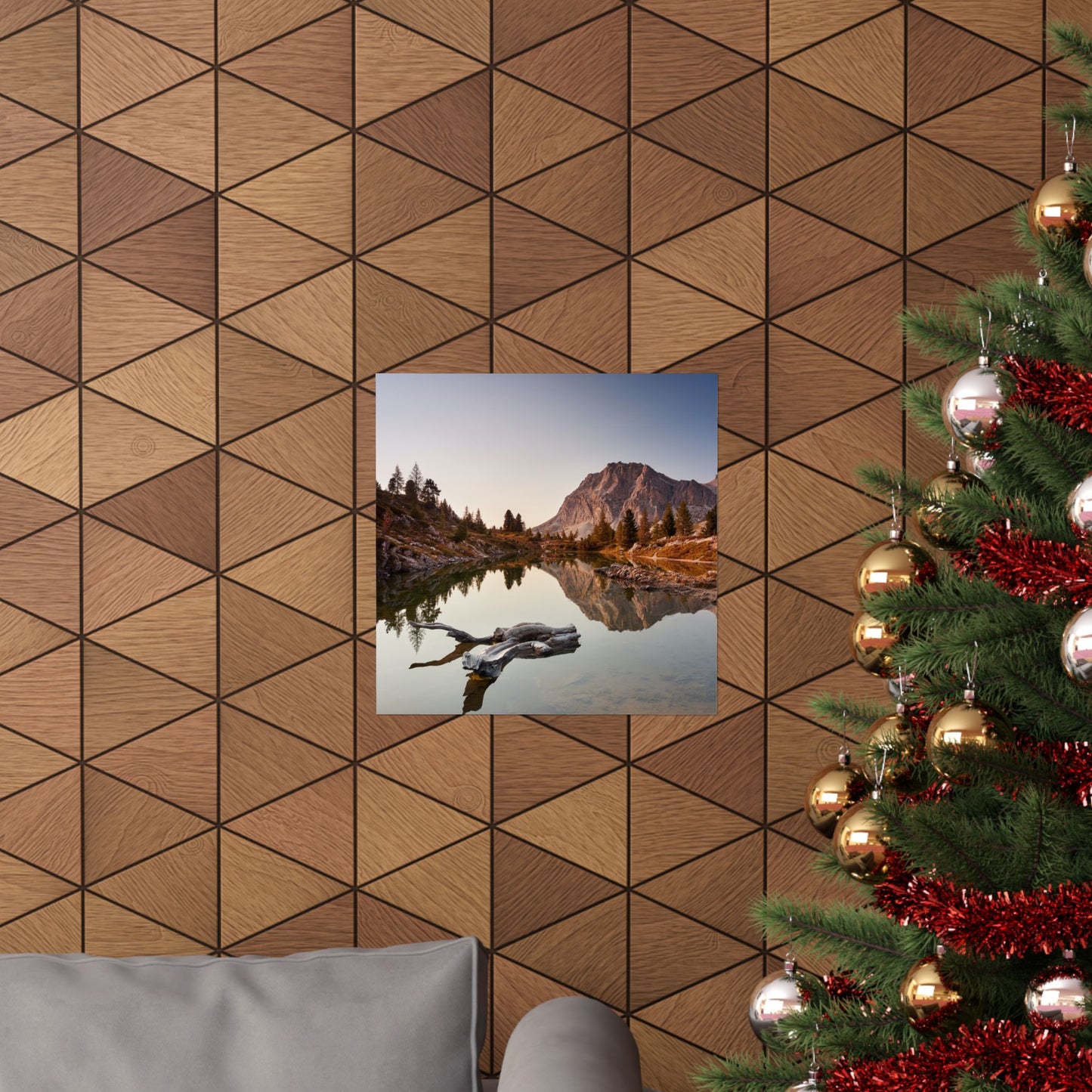 Decorative wall with geometric wood pattern, framed picture of a lake, and Christmas tree with ornaments.