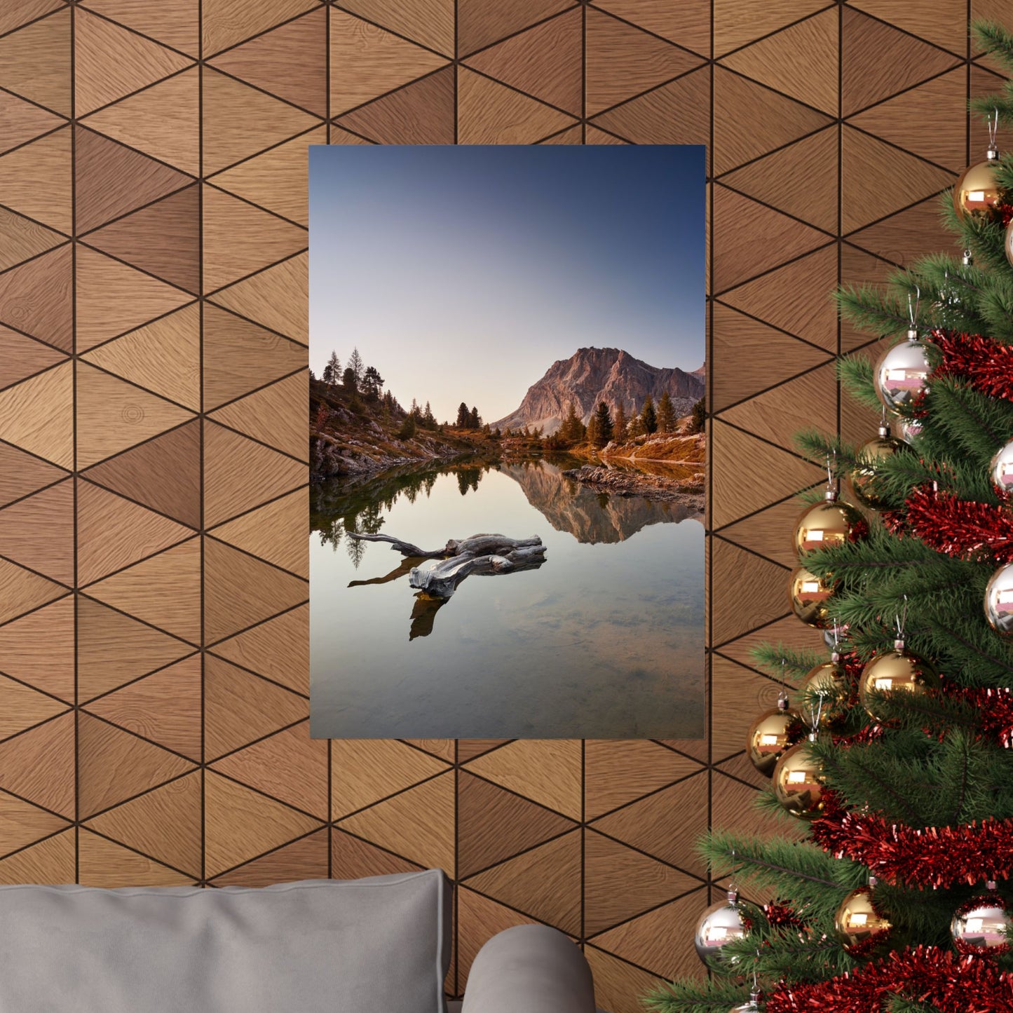 Poster of a mountain lake scene on a wooden wall with a decorated Christmas tree.
