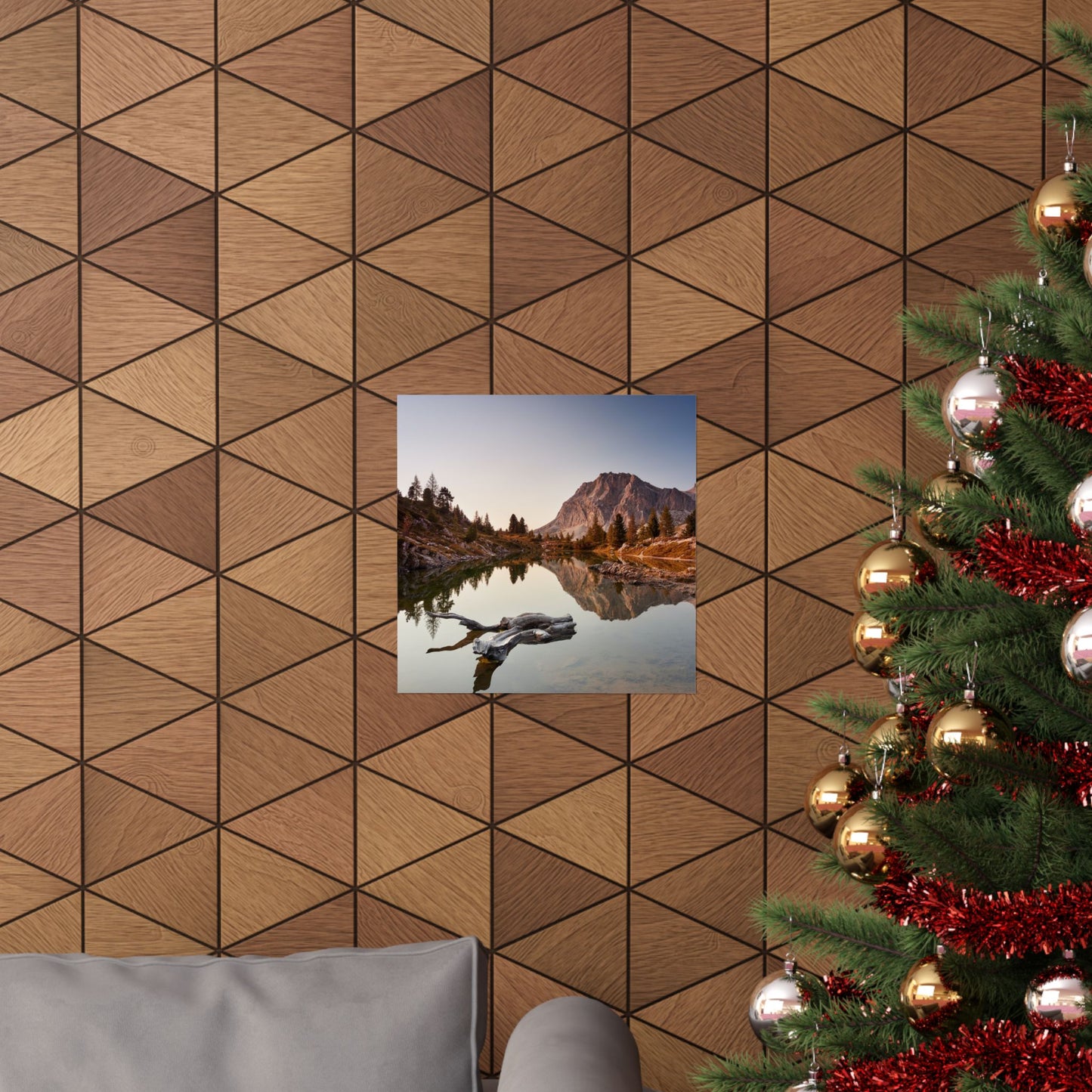 Wooden wall with geometric pattern, framed picture of a mountain lake, and Christmas tree with decorations.