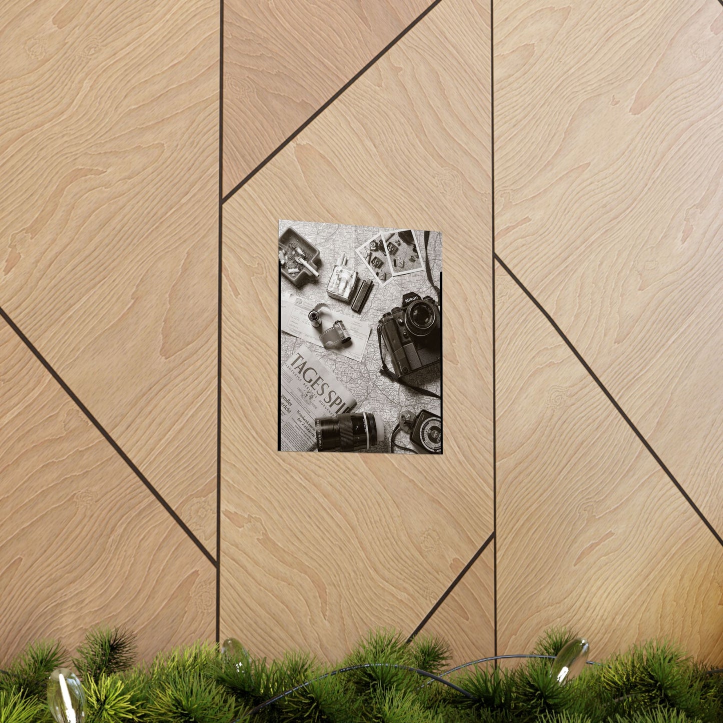 Framed photo of vintage cameras on a wooden wall with greenery at the bottom.