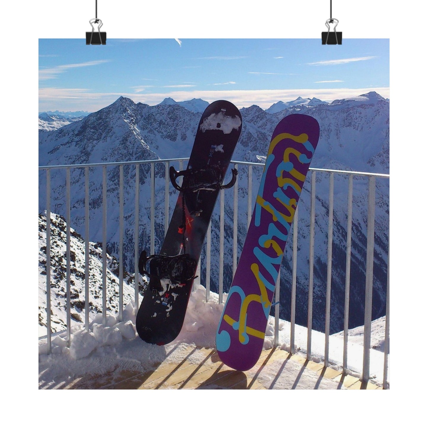 Two snowboards against a mountainous background