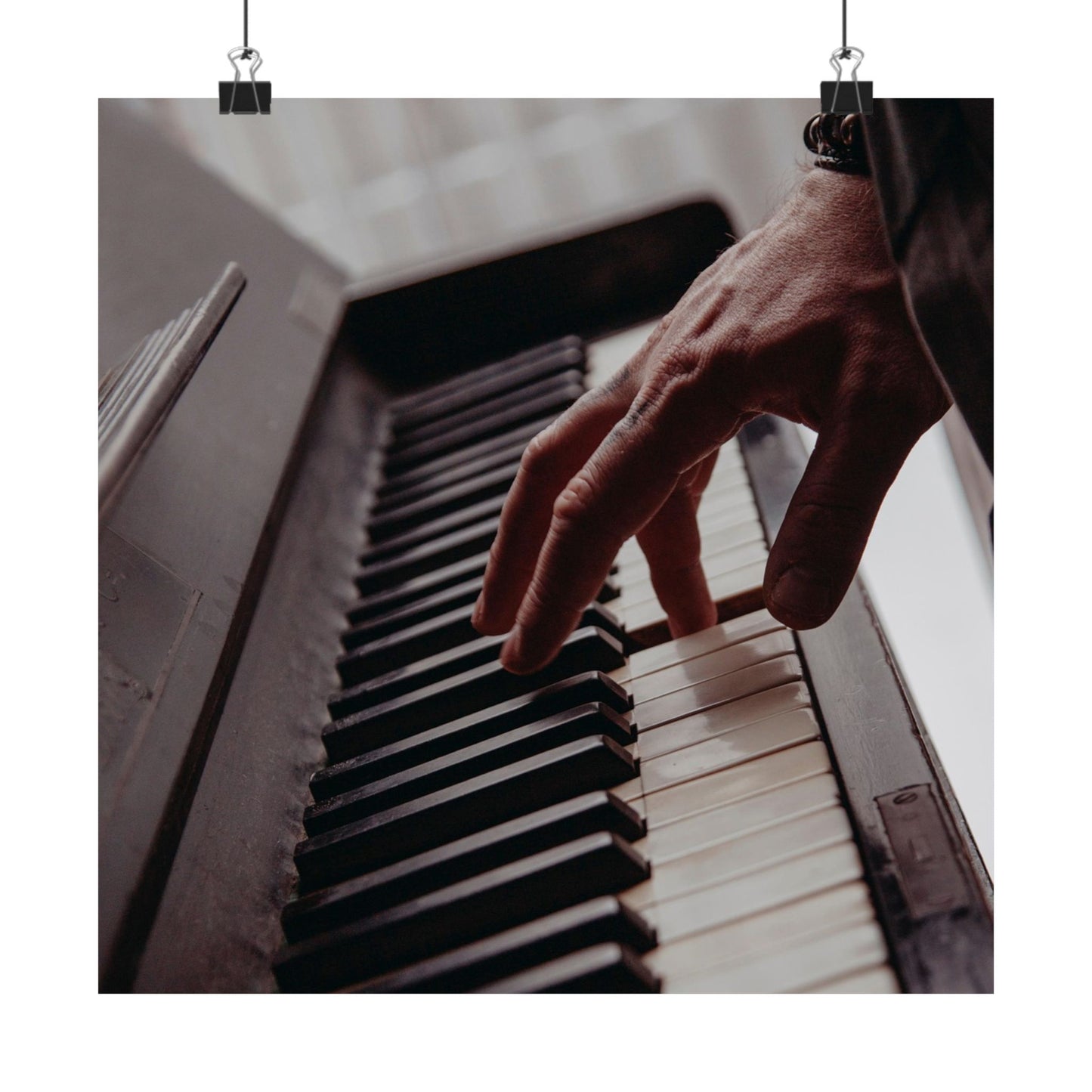 Hand playing a piano with a blurred background