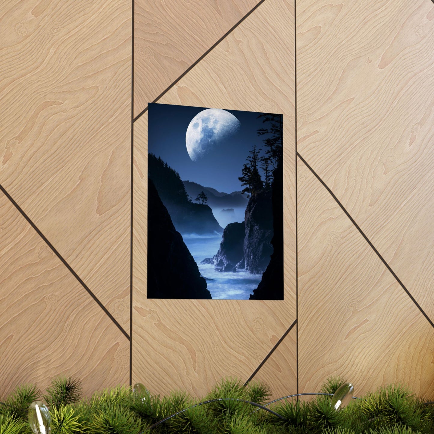 Framed artwork of a moonlit coastal scene on a wooden wall.