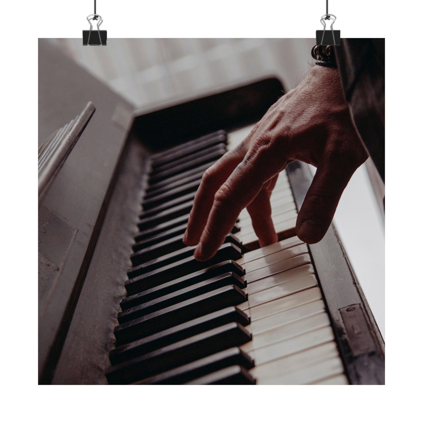 Hand playing a piano with a blurred background