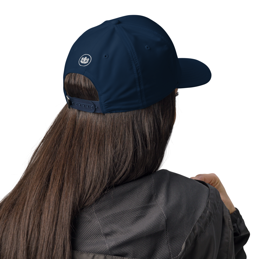 Person wearing a navy blue cap with a logo on a white background