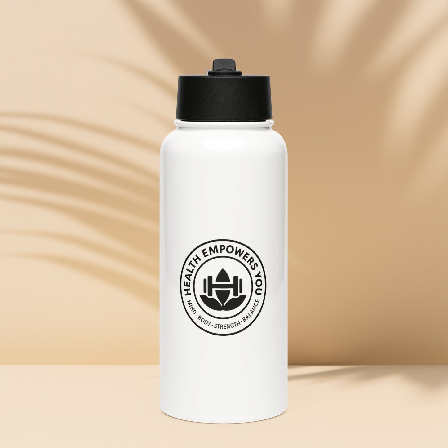 White water bottle with black lid and logo on a beige background