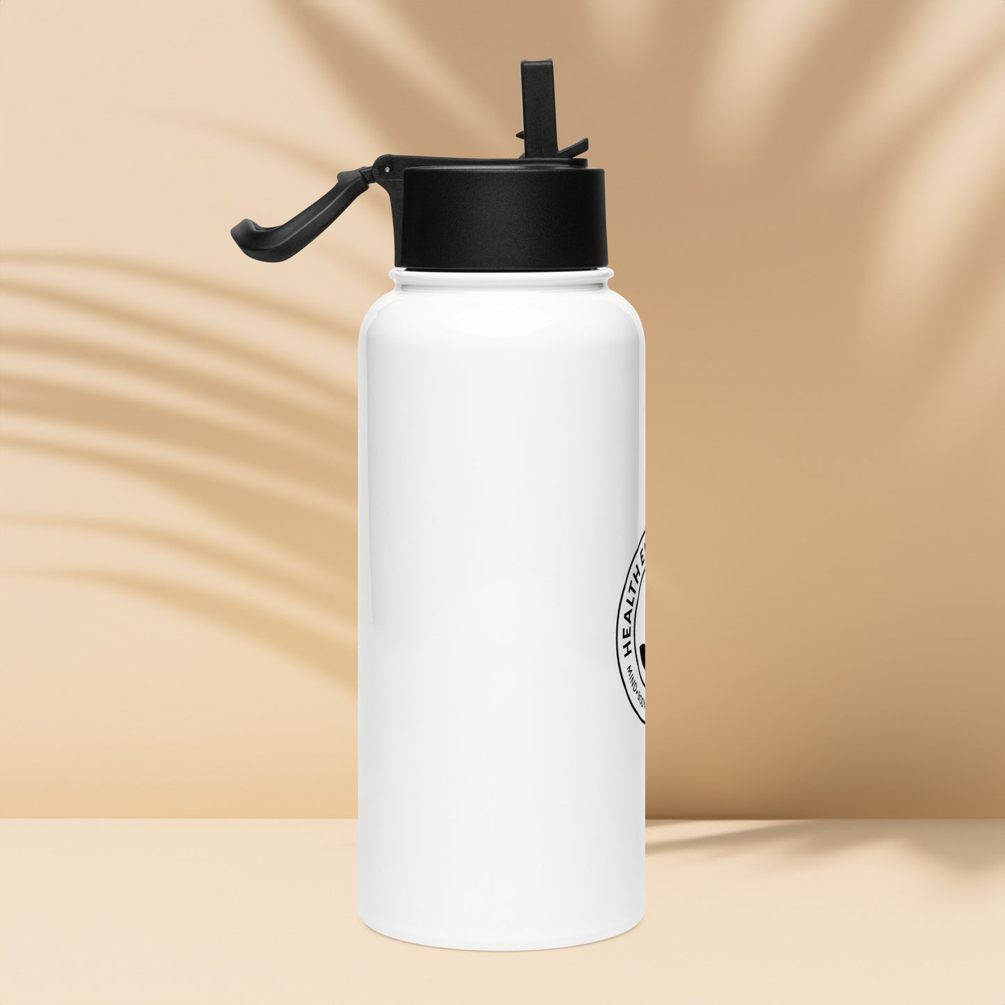 White water bottle with black cap on a beige background