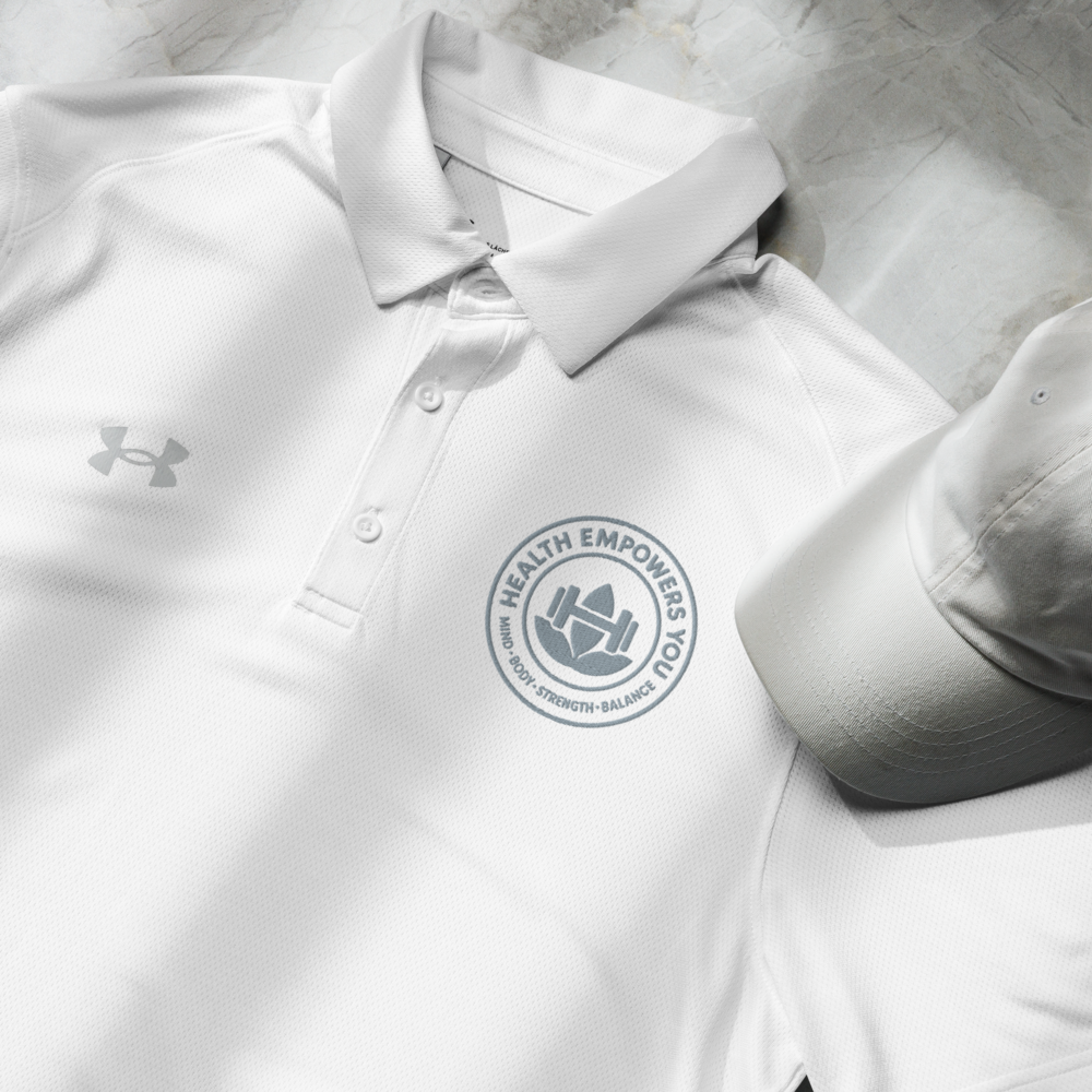 White polo shirt with a logo and a cap on a light gray surface