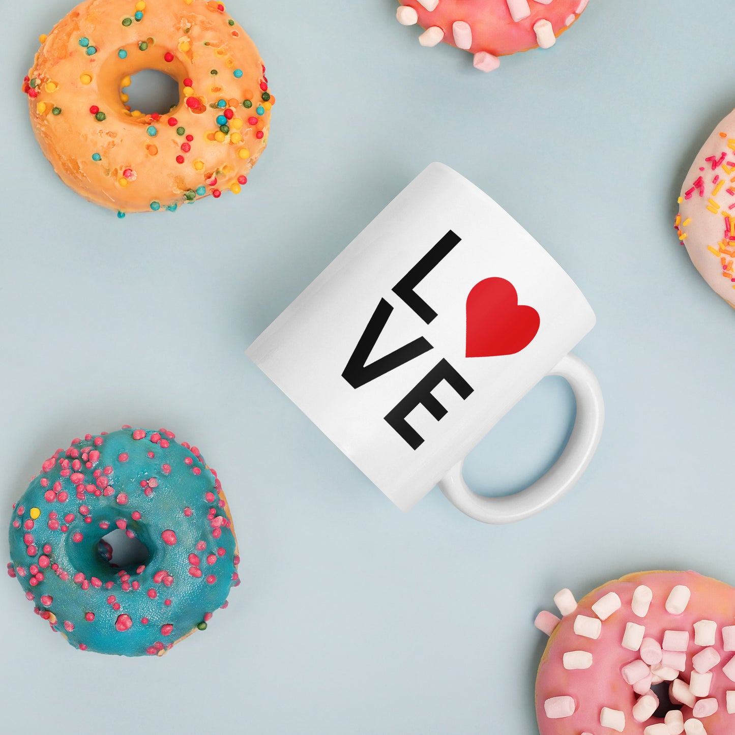 "White ceramic coffee mug with black text saying Love with red heart symbol"