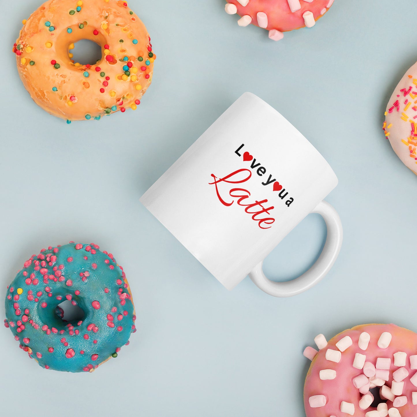 "White ceramic coffee mug with black text saying Love You a Latte with heart"