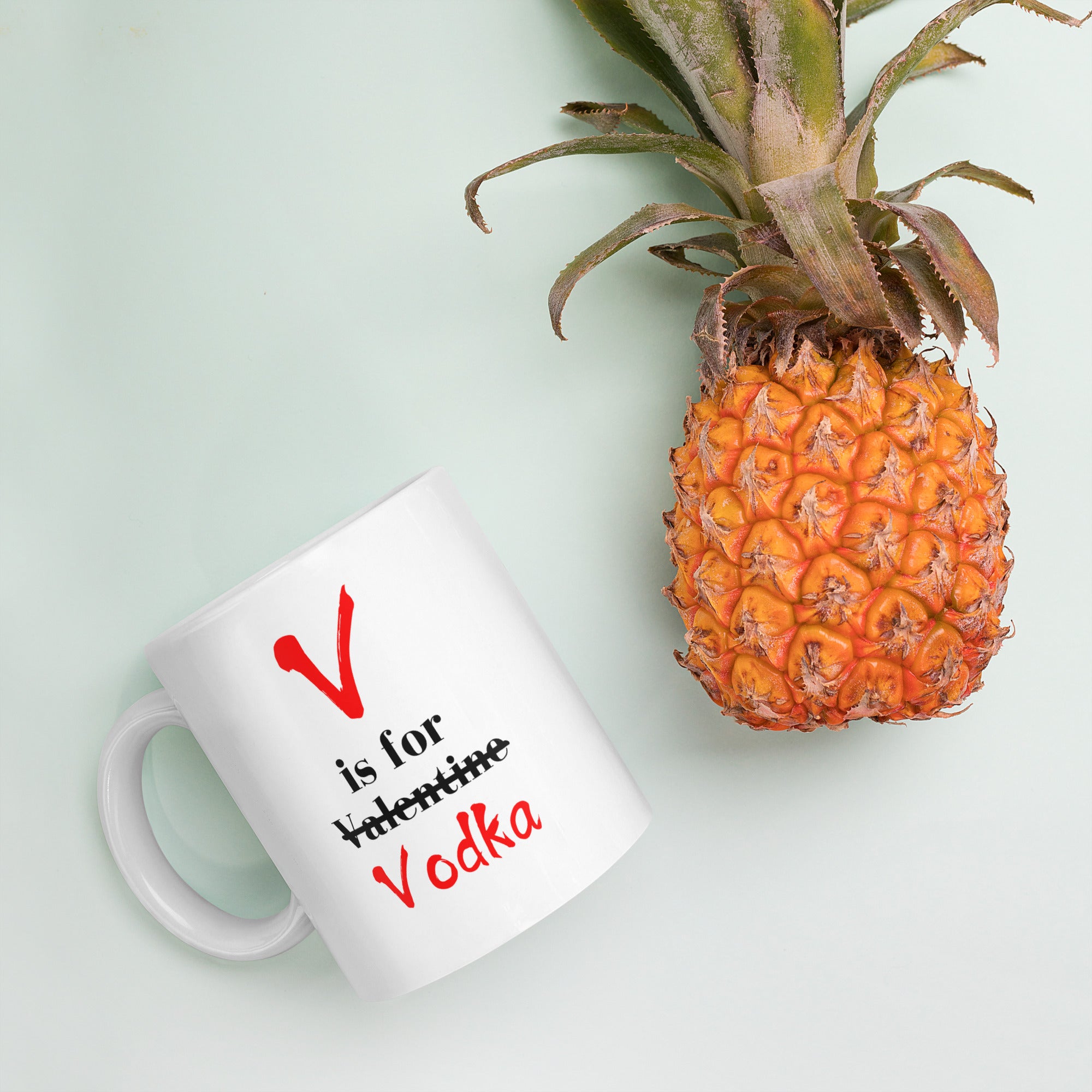 "White ceramic coffee mug with black text saying V Is For Valentine crossed out Vodka"
