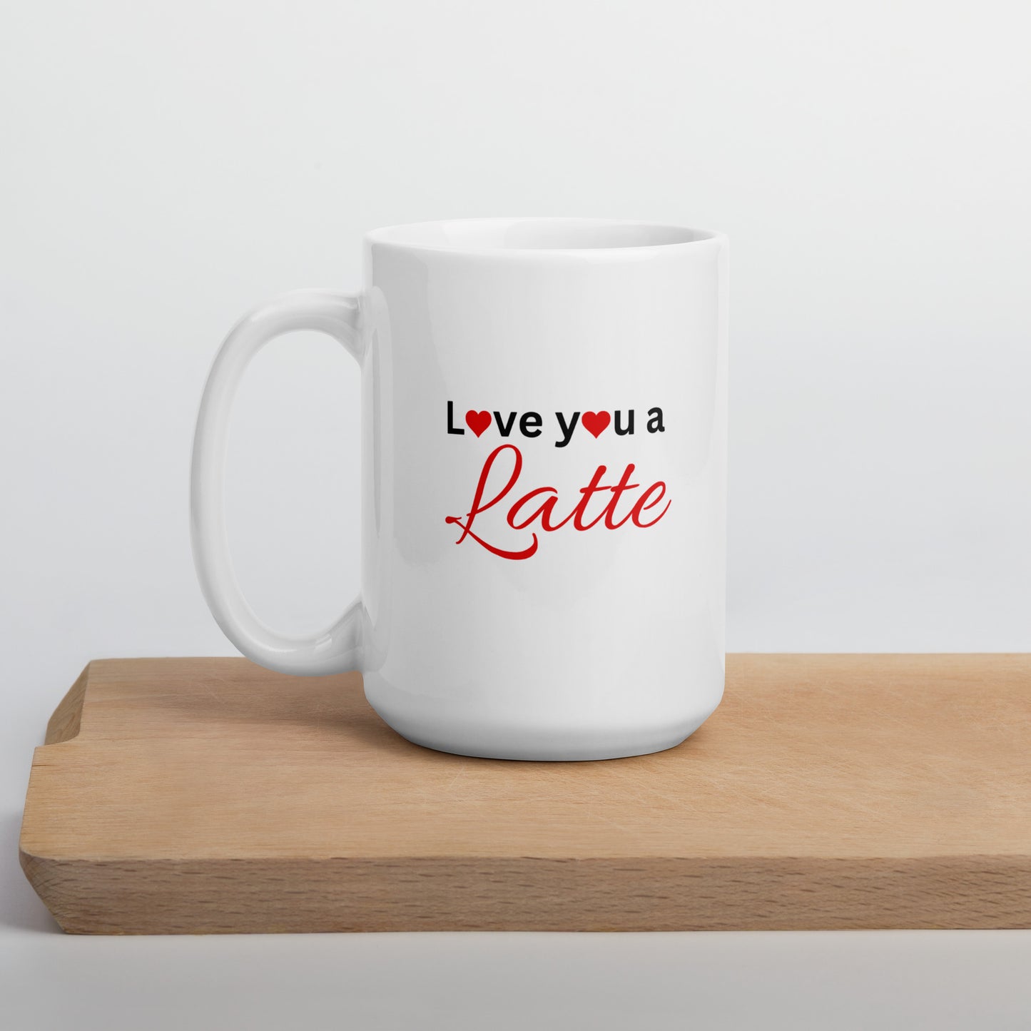 A white ceramic mug with the text 'I love you a latte' printed in red and a heart symbol, placed on a wooden surface.