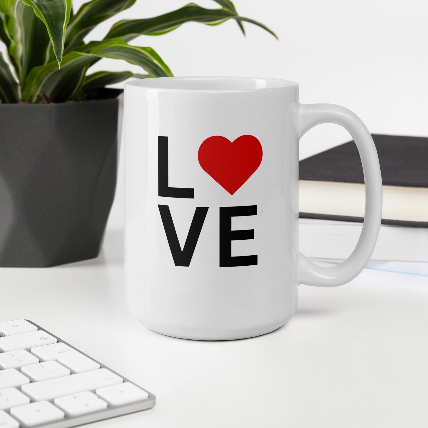 "White ceramic coffee mug with black text saying Love with red heart symbol"