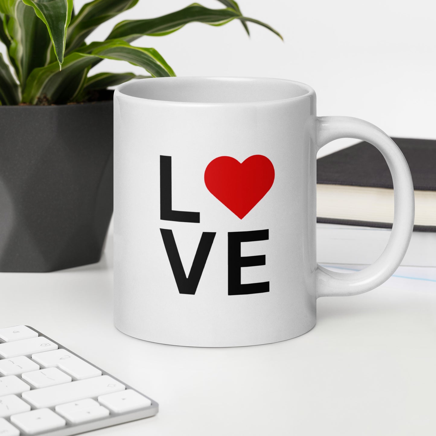 "White ceramic coffee mug with black text saying Love with red heart symbol"