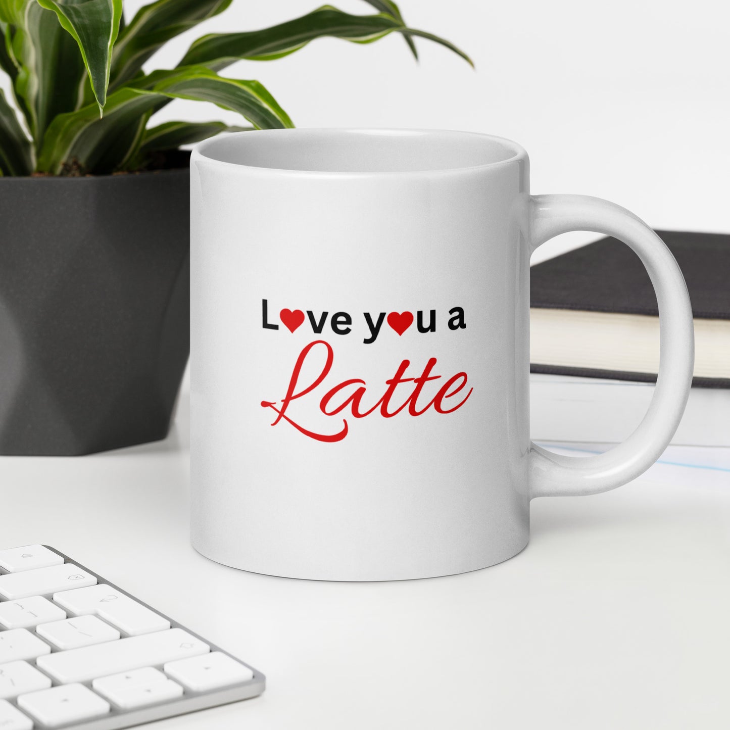 "White ceramic coffee mug with black text saying Love You a Latte with heart"