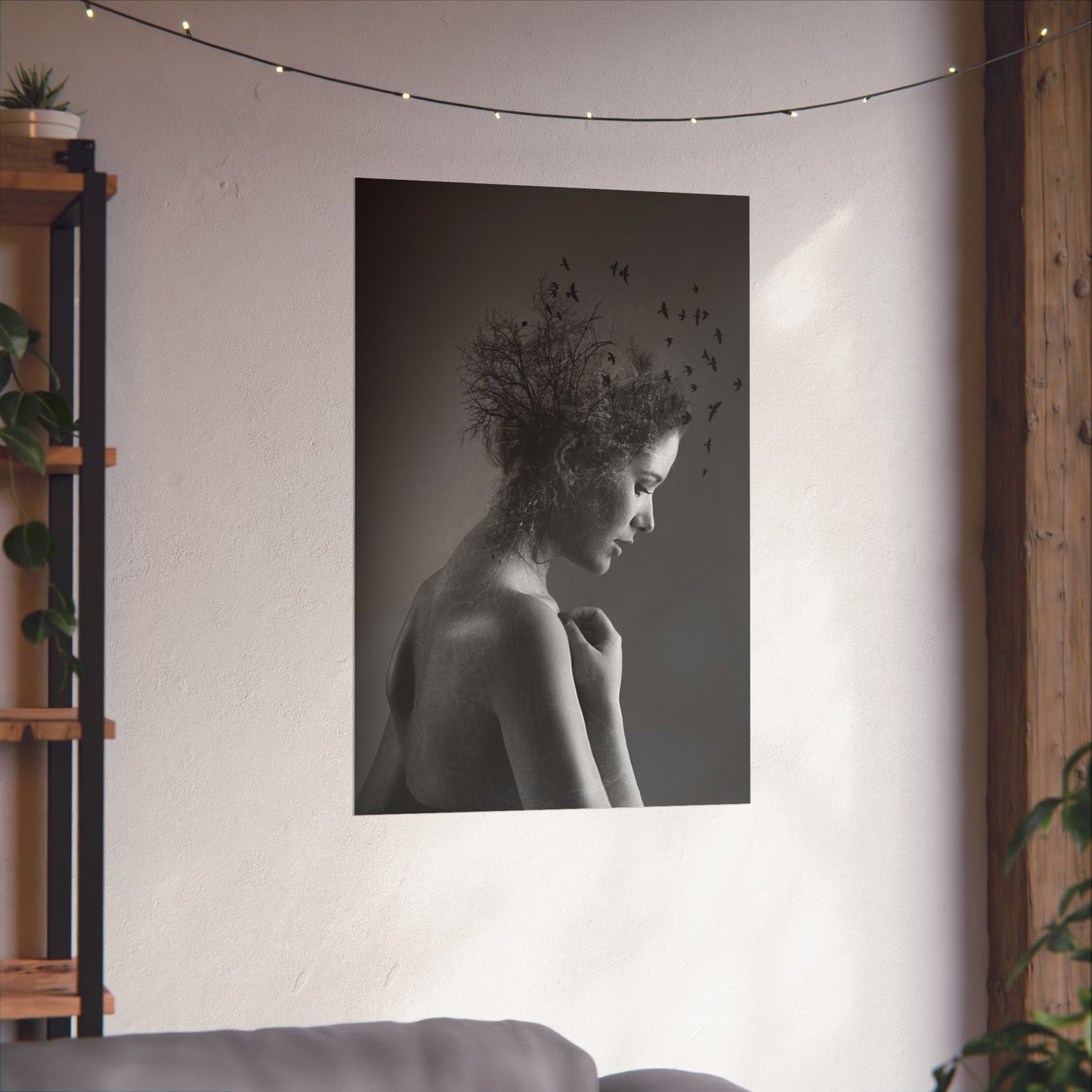 Black and white portrait of a woman with birds on her head hanging on a wall.