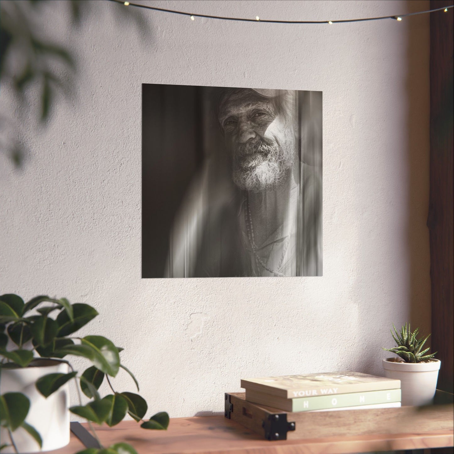 Poster of a man with a beard on a wall above a wooden shelf with books and plants.