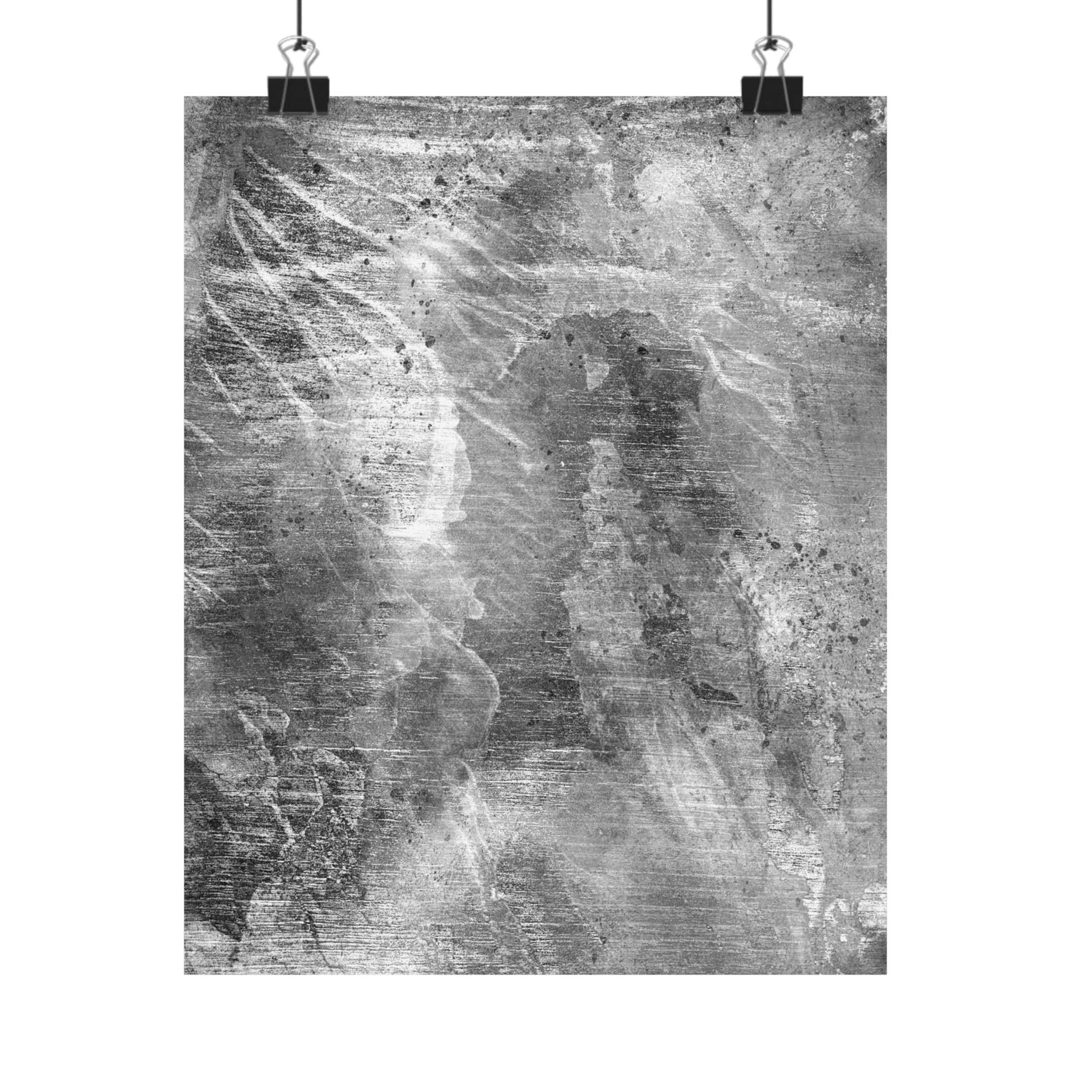 Abstract black and white artwork on a textured surface with two clips holding it up.