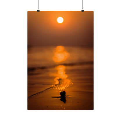 Sunset over water with a small object on the beach