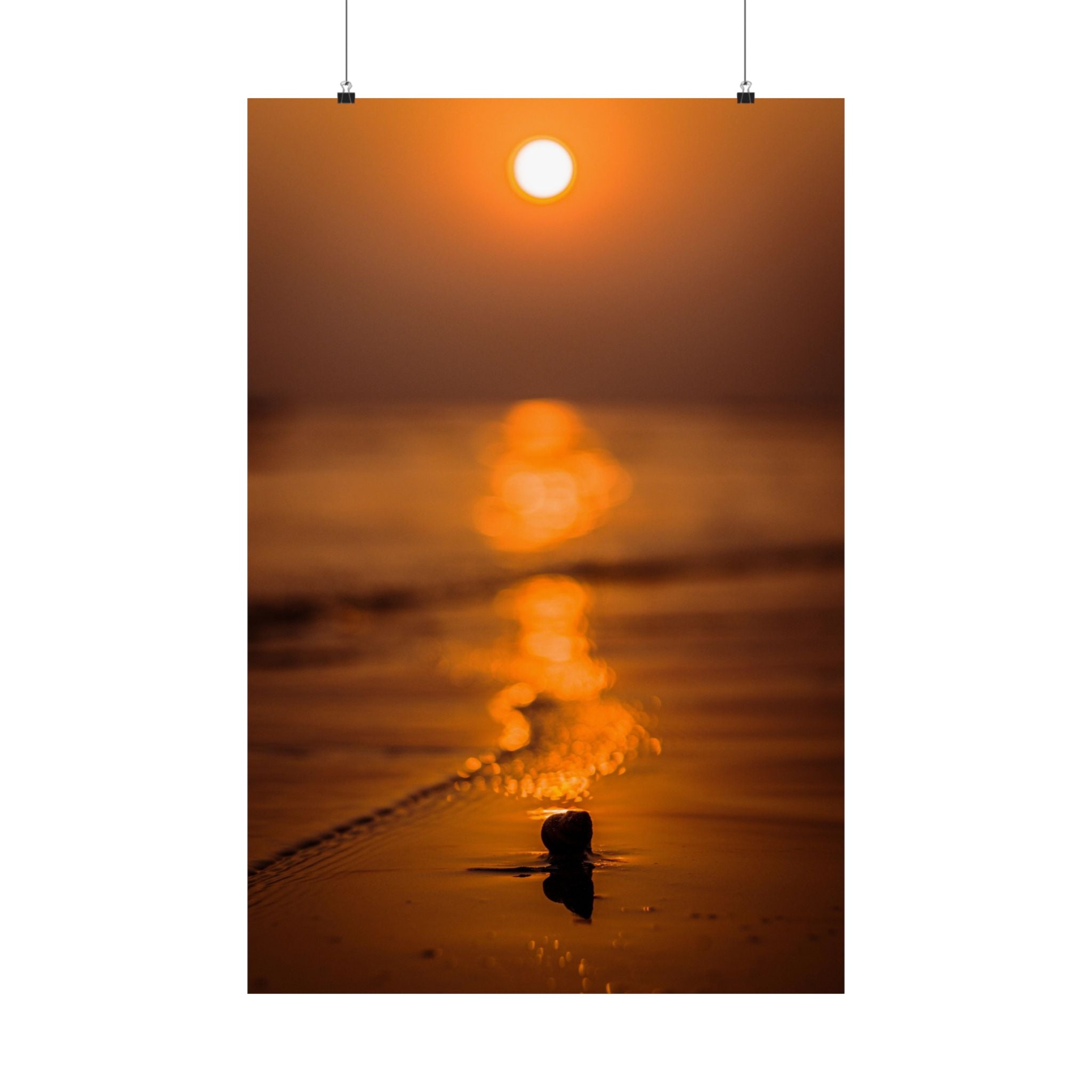 Sunset over water with a small rock in the foreground