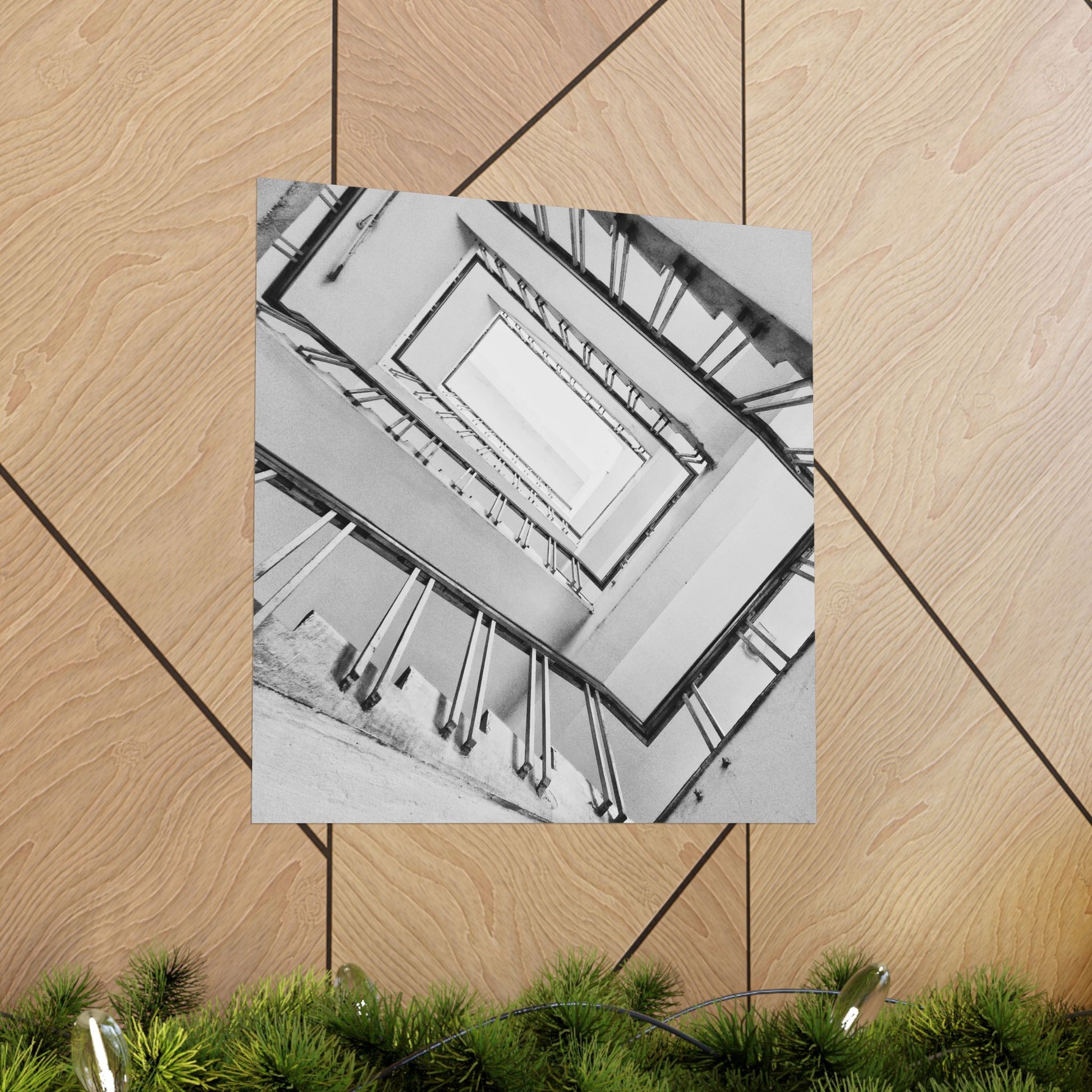 Black and white photo of a staircase on a wooden floor with greenery at the bottom.