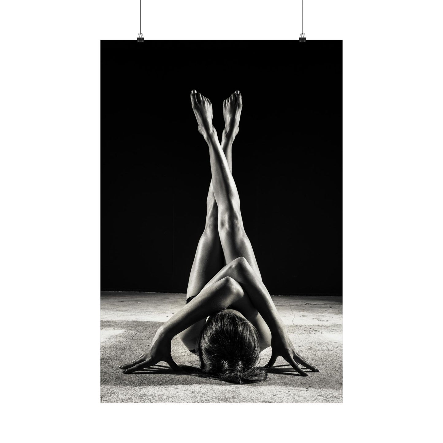 Black and white photograph of a person in a yoga pose with legs extended upwards.