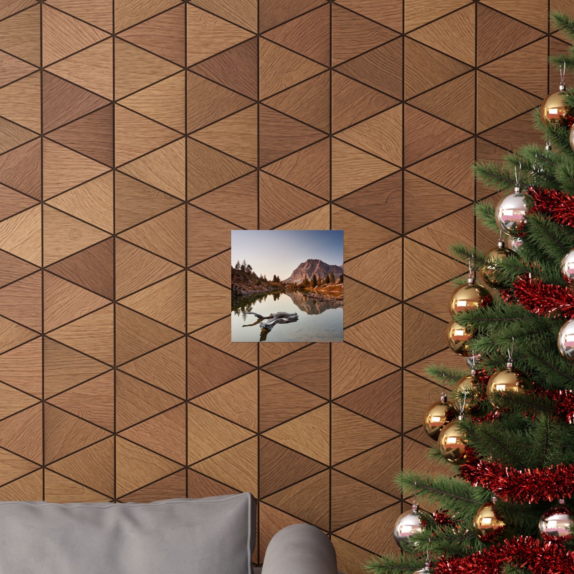 Wooden wall with geometric pattern, small picture of a mountain lake, and Christmas tree with decorations.