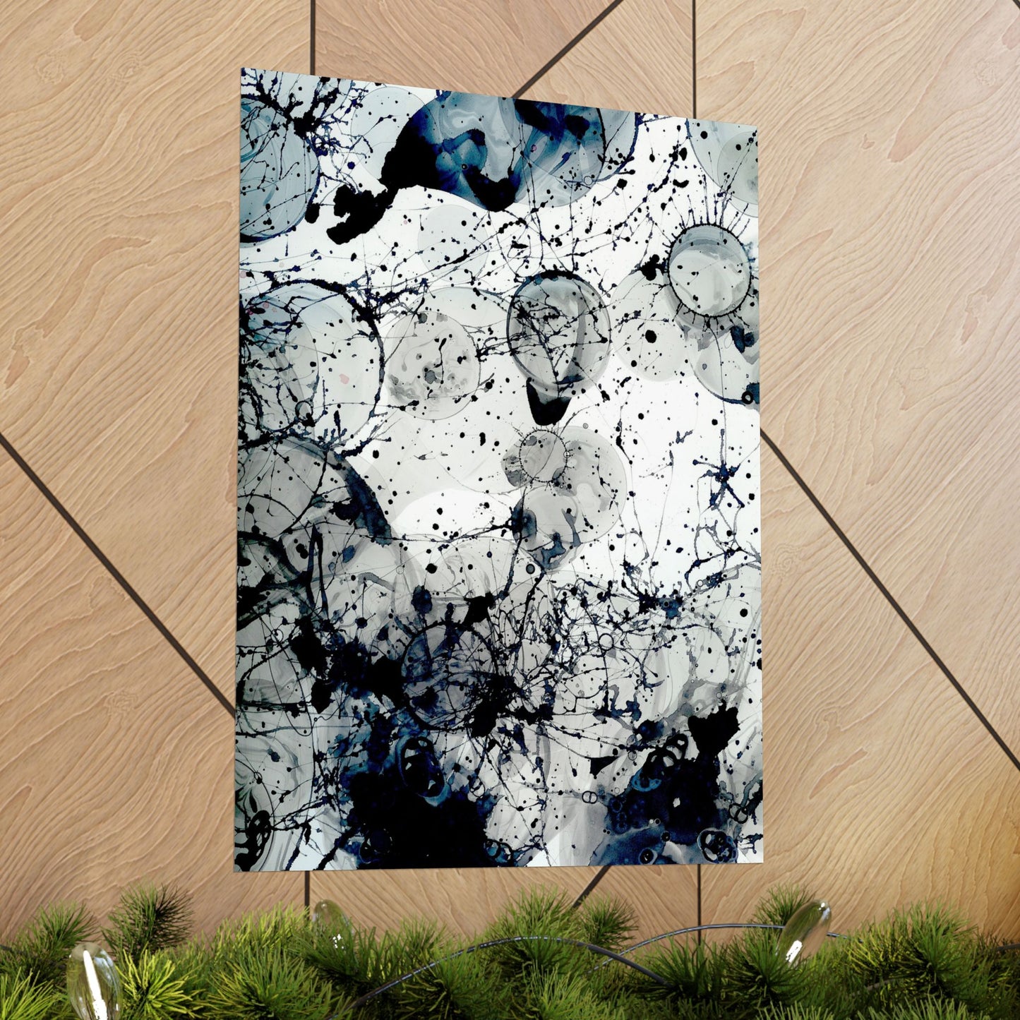 Abstract art print with blue and black splashes on a wooden floor