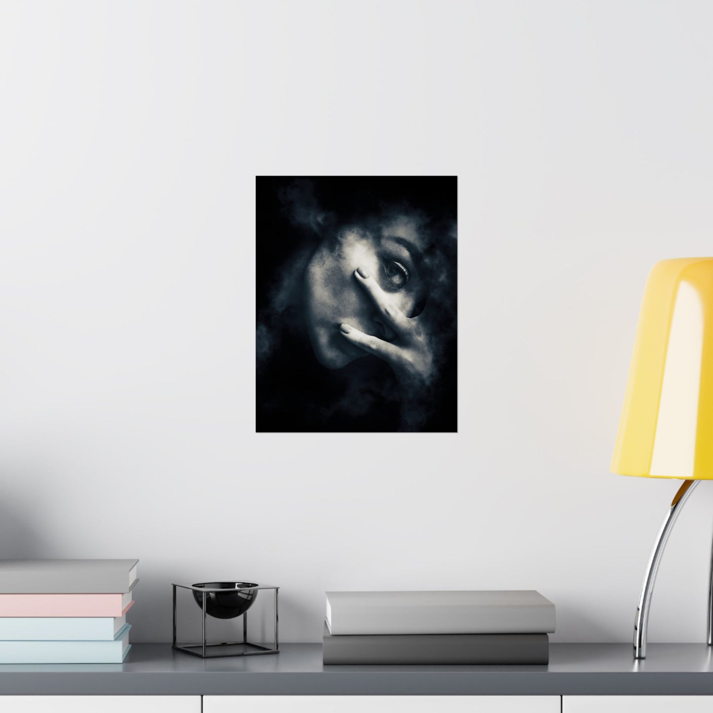 Framed artwork of a wolf's face on a wall above a shelf with books and a lamp.