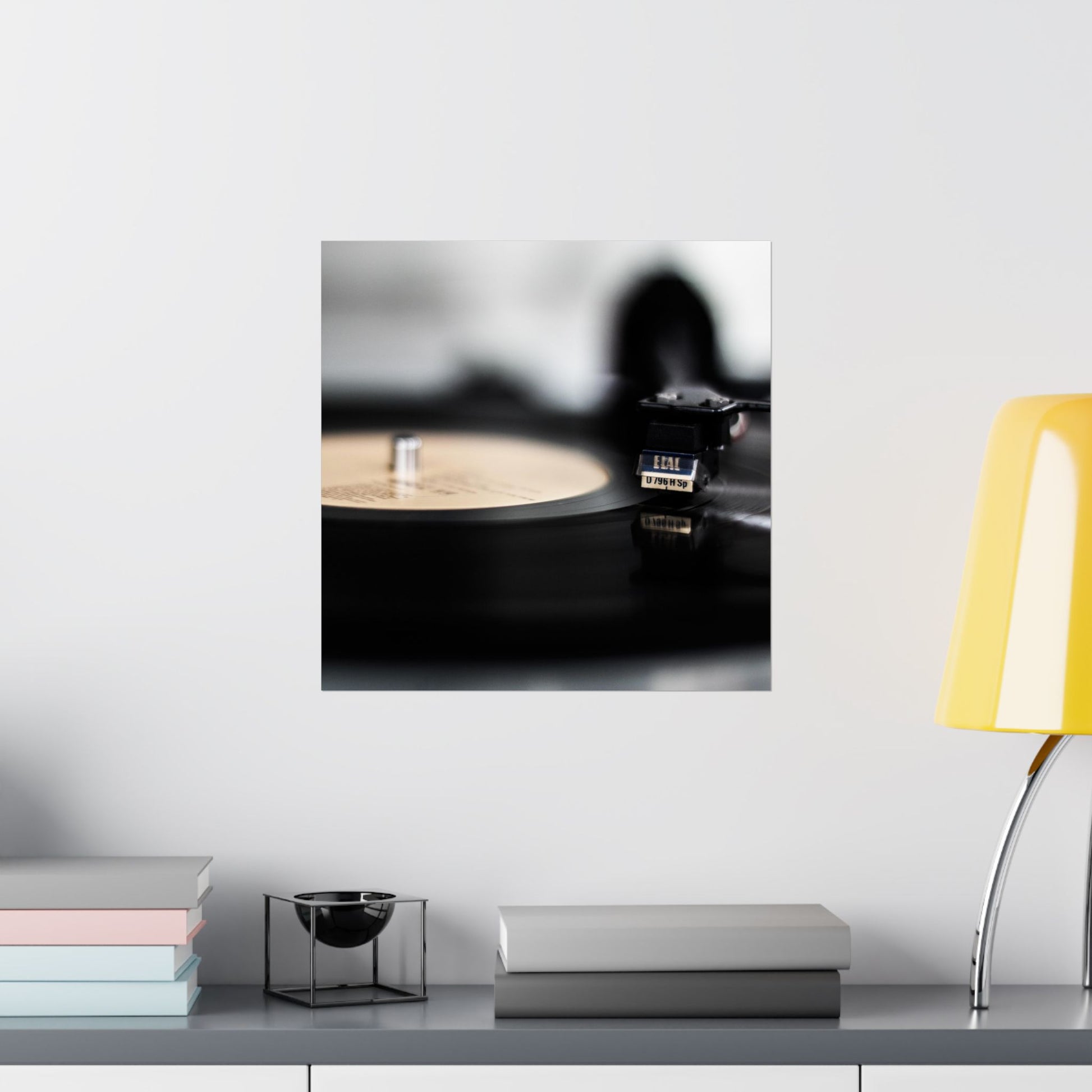 Framed picture of a vinyl record player on a shelf with books and a lamp.