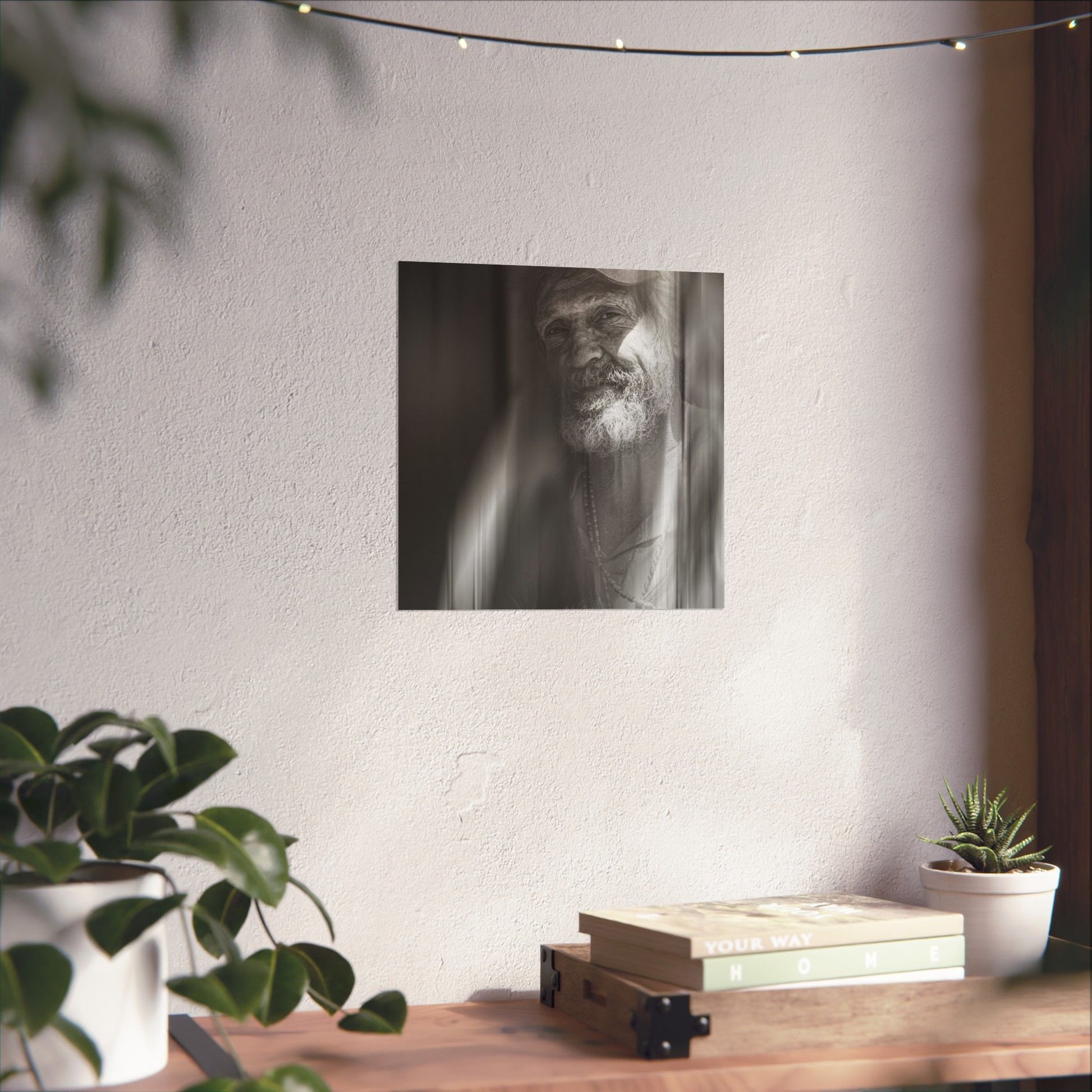 Poster of a man on a wall above a wooden shelf with books and plants.