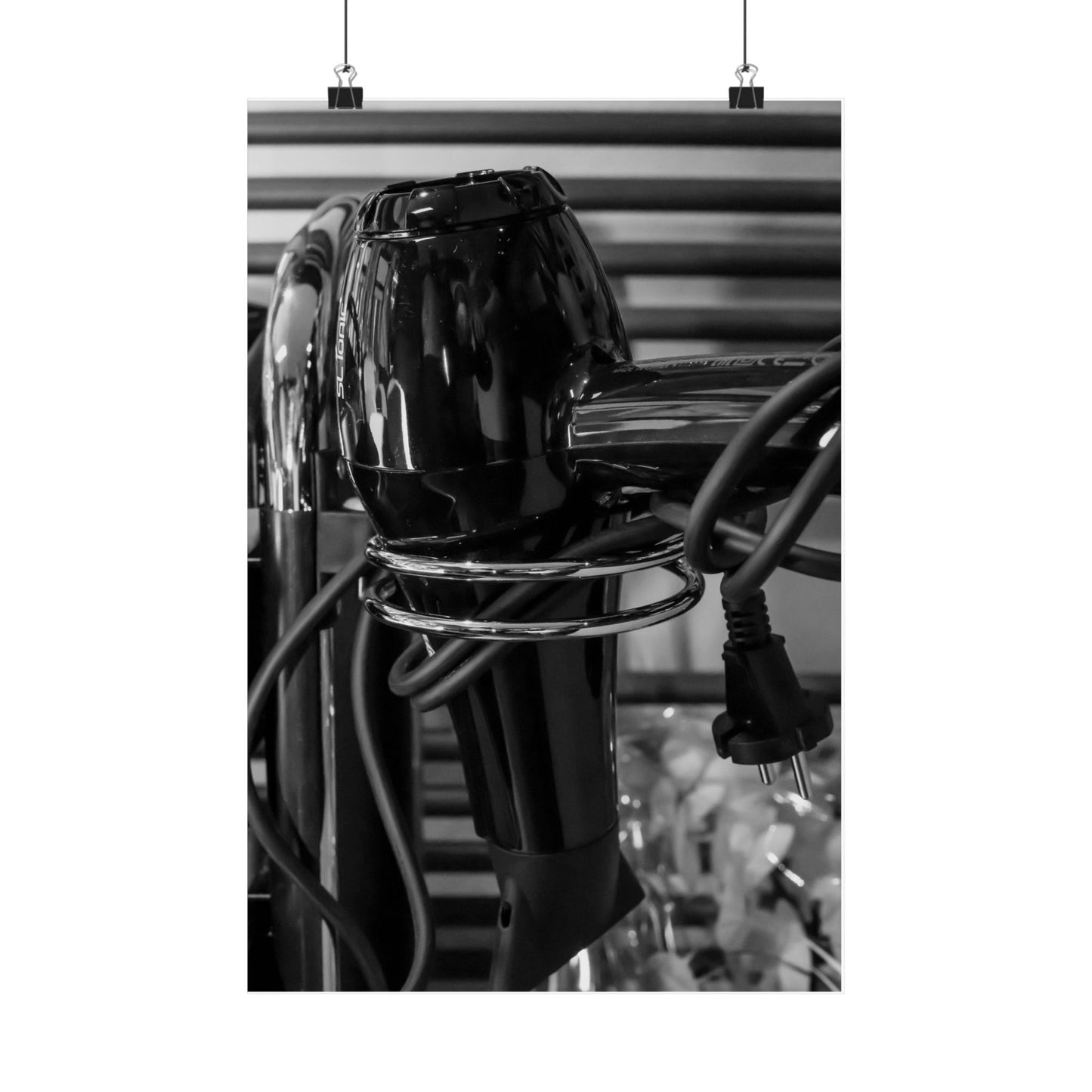 Close-up of a black hair dryer with visible branding on a blurred background