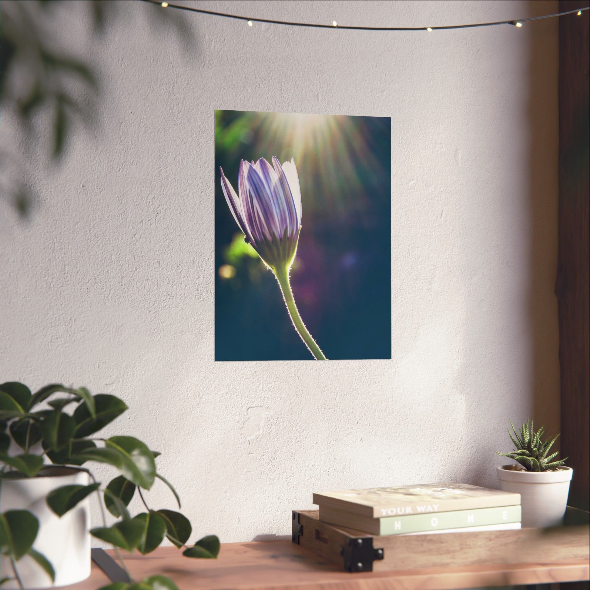 Flower painting on a wall above a wooden desk with plants