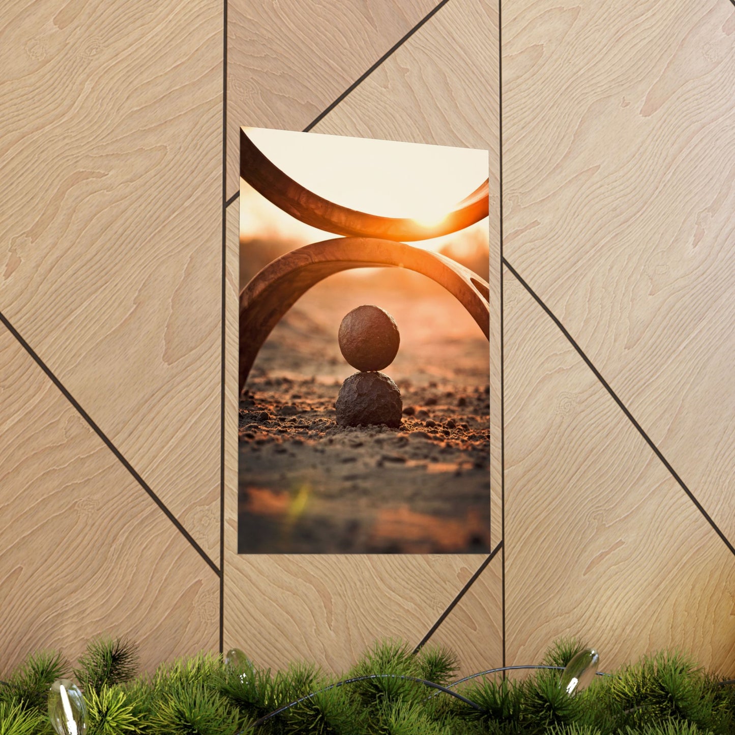 Framed artwork of a sunset scene with a stone ball on a wooden wall.