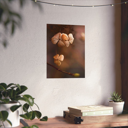 Decorative wall art of dried flowers on a white wall above a wooden table with plants.