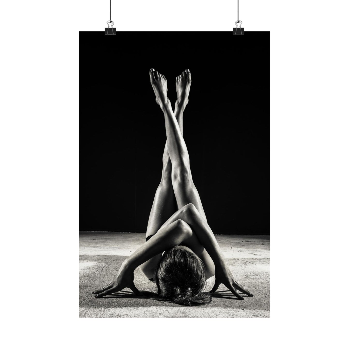Black and white photo of a person in a yoga pose with a dark background