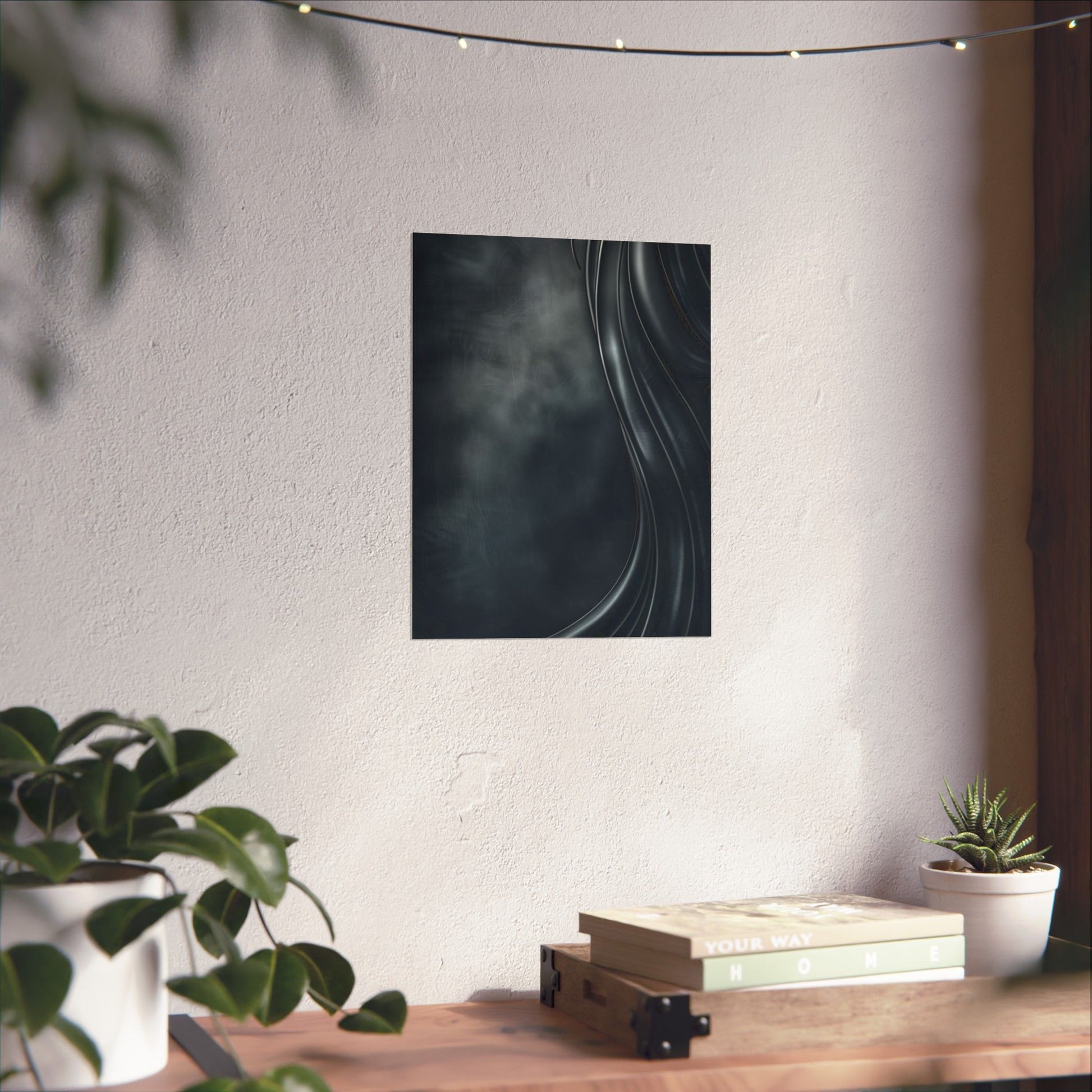 Abstract art piece on a wall above a wooden table with plants and books.