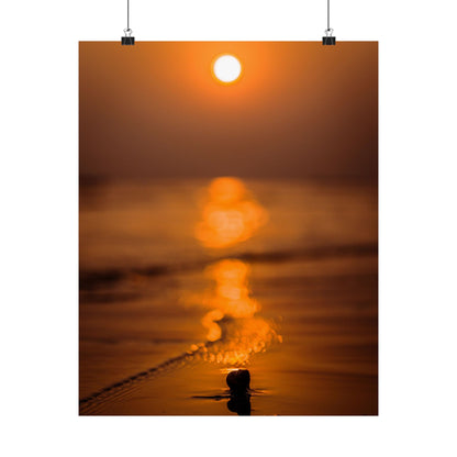 Sunset over water with a person standing on a dock, creating a silhouette.