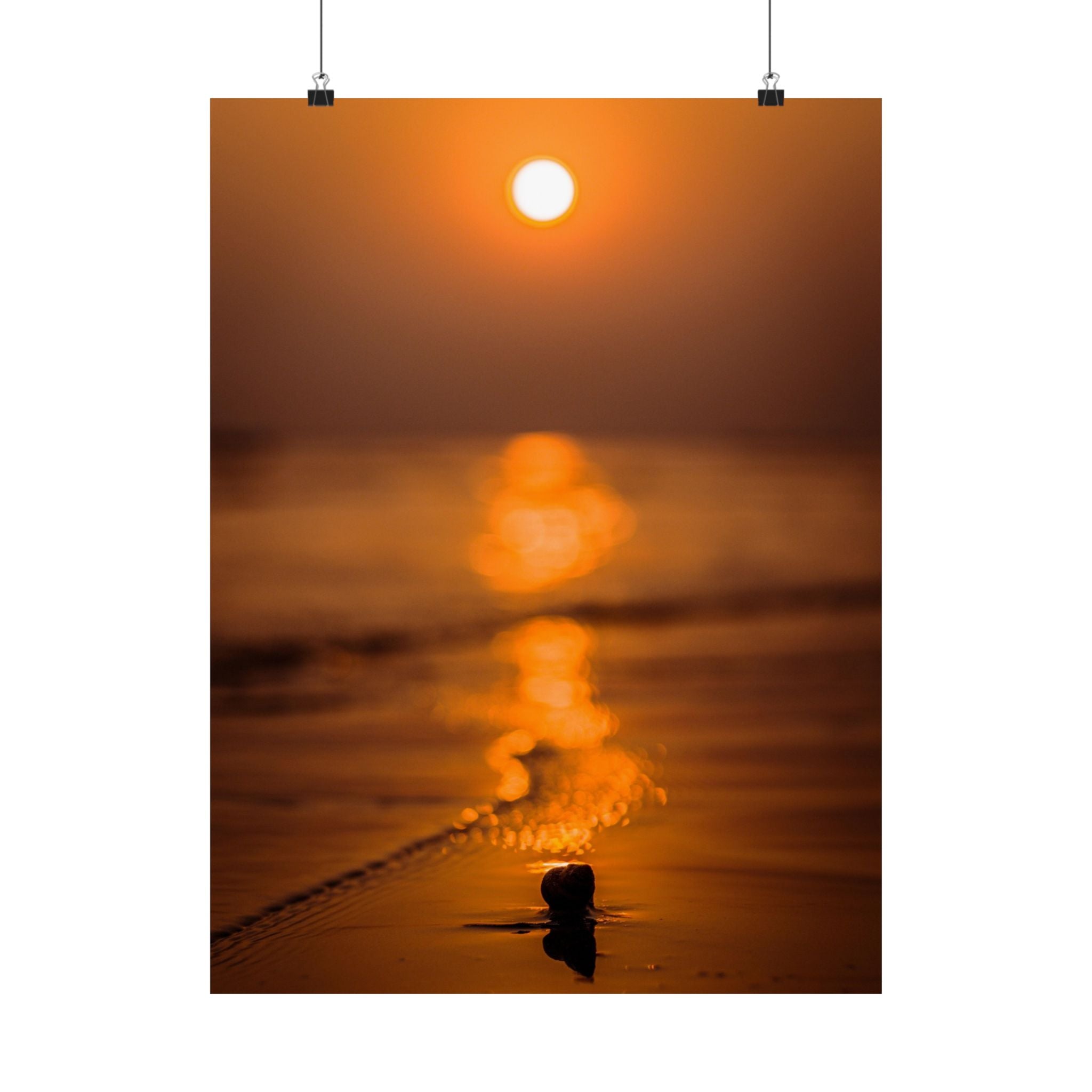 Sunset over water with a person standing in the foreground