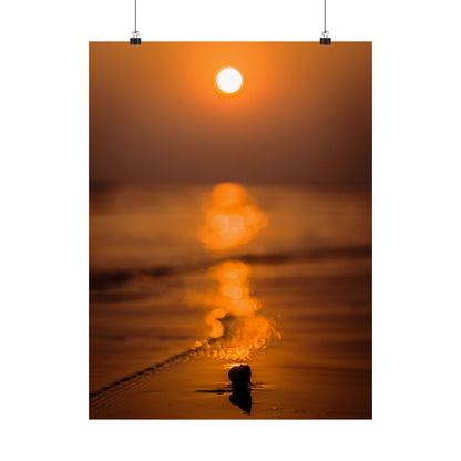 Sunset over water with a person standing in the foreground